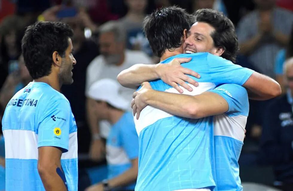 Argentina's Maximo Gonzalez (L) and Horacio Zeballos (C) celebrate with team captain Gaston Gaudio after defeating Colombia in the doubles tennis match and winning the Davis Cup World Group play off series 3-0 at the Aldo Cantoni stadium in San Juan, Argentina, on September 15, 2018. (Photo by Andres Larrovere / AFP) san juan  campeonato torneo copa davis 2018 tenis partido dobles partido tenistas equipo argentina colombia