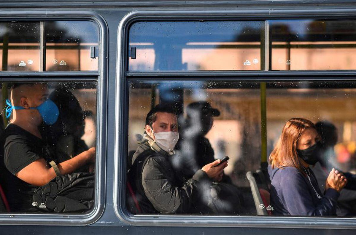 People wear face masks in a bus in Buenos Aires, on April 17, 2020 amid the COVID-19 coronavirus pandemic. (Photo by RONALDO SCHEMIDT / AFP)  barbijo barbijos colectivo