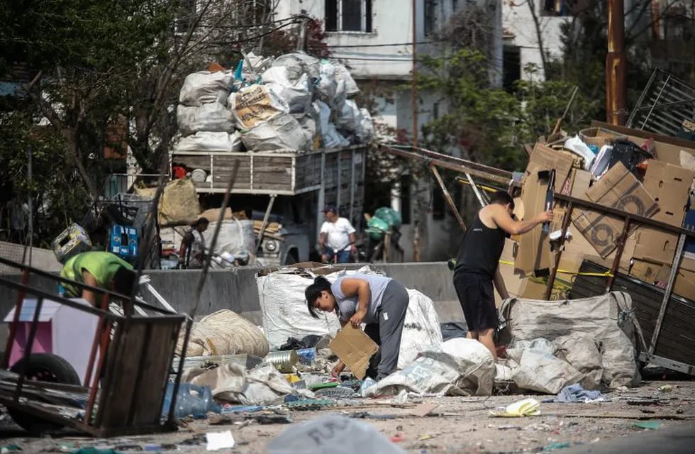 Varias personas juntan cartones y basura este lunes como método de subsistencia en una villa de la ciudad de Buenos Aires. EFE/Juan Ignacio Roncoroni.