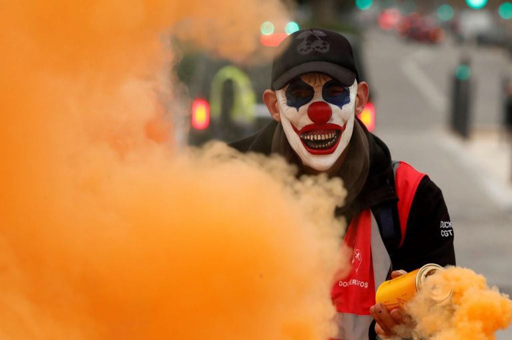 Un protestante con una máscara sostiene un bote de humo en Marsella, Francia (EFE/Guillaume Horcajuelo)