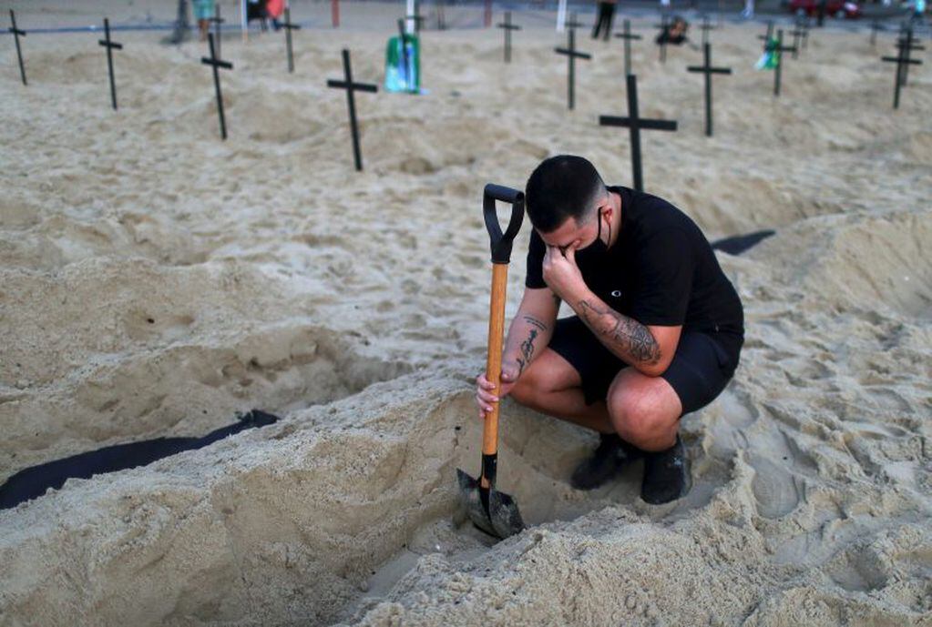 Un activista llora frente a una tumba. (REUTERS)