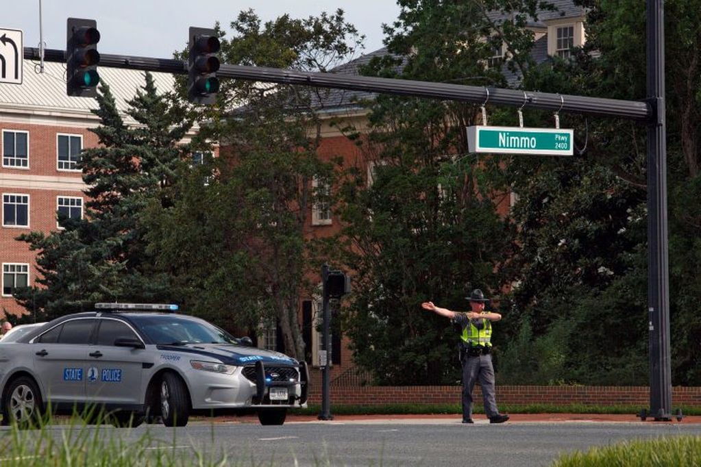 Oficial de tránsito desvía el tráfico lejos de los acontecimientos (Kaitlin McKeown/The Virginian-Pilot via AP).