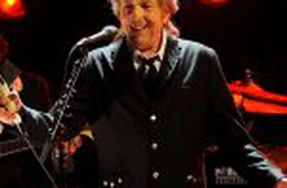 FILE  - In this Jan. 12, 2012, file photo, Bob Dylan performs in Los Angeles. Dylan, who was named the winner of the 2016 Nobel Prize in literature on Oct. 13, 2016, says he u201cabsolutelyu201d wants to attend the Nobel Prize Award Ceremony u201cif itu2019s at all possi