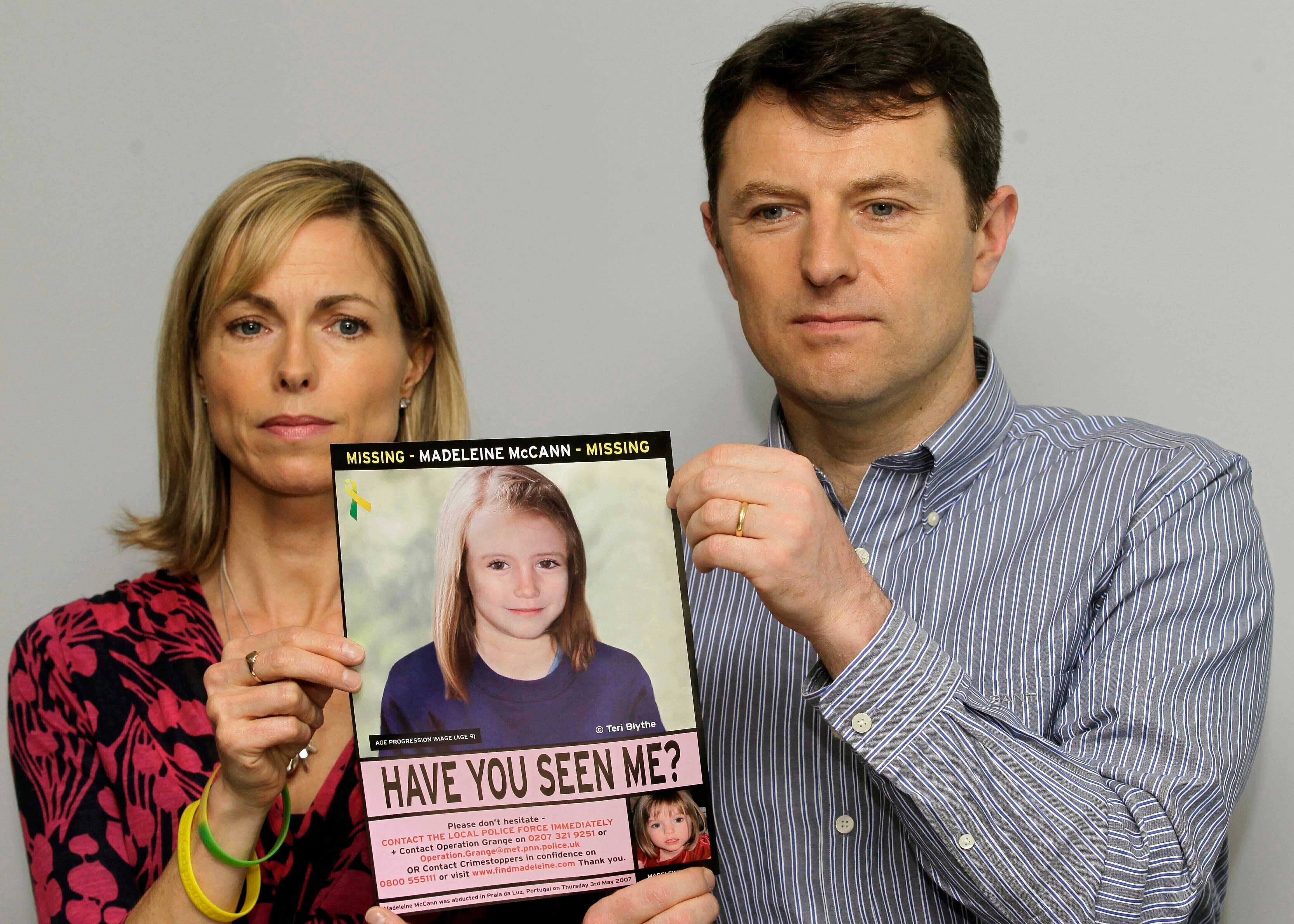 ARCHIVO - Kate y Gerry McCann posan para los medios con un cartel de búsqueda que ofrece una imagen generada por computadora sobre la posible progresión de la edad de su hija Madeleine, que desapareció en Portugal en 2007, durante una conferencia de prensa en Londres, el 2 de mayo de 2012. (AP Foto/Sang Tan, archivo)