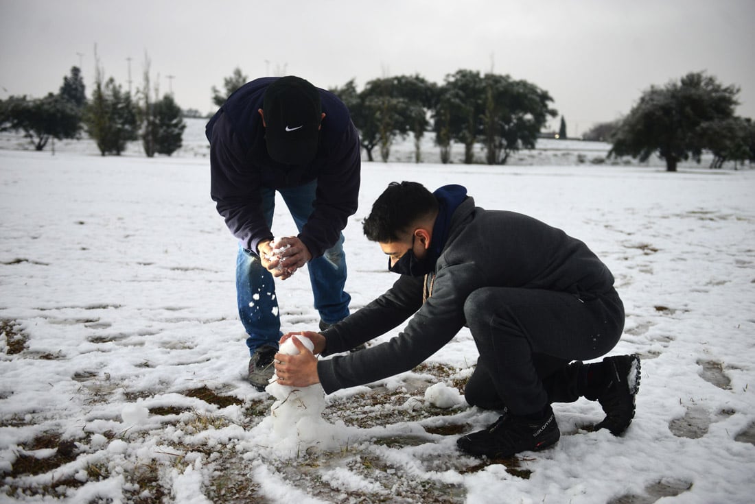 Una intensa nevada cayó en la provincia de Córdoba durante la noche y parte de la mañana del miércoles. 
Parque de los Niños Urbanos, frente al aeropuerto.  Familias juegan y arman muñecos de nieve.  (Nicolás Bravo)