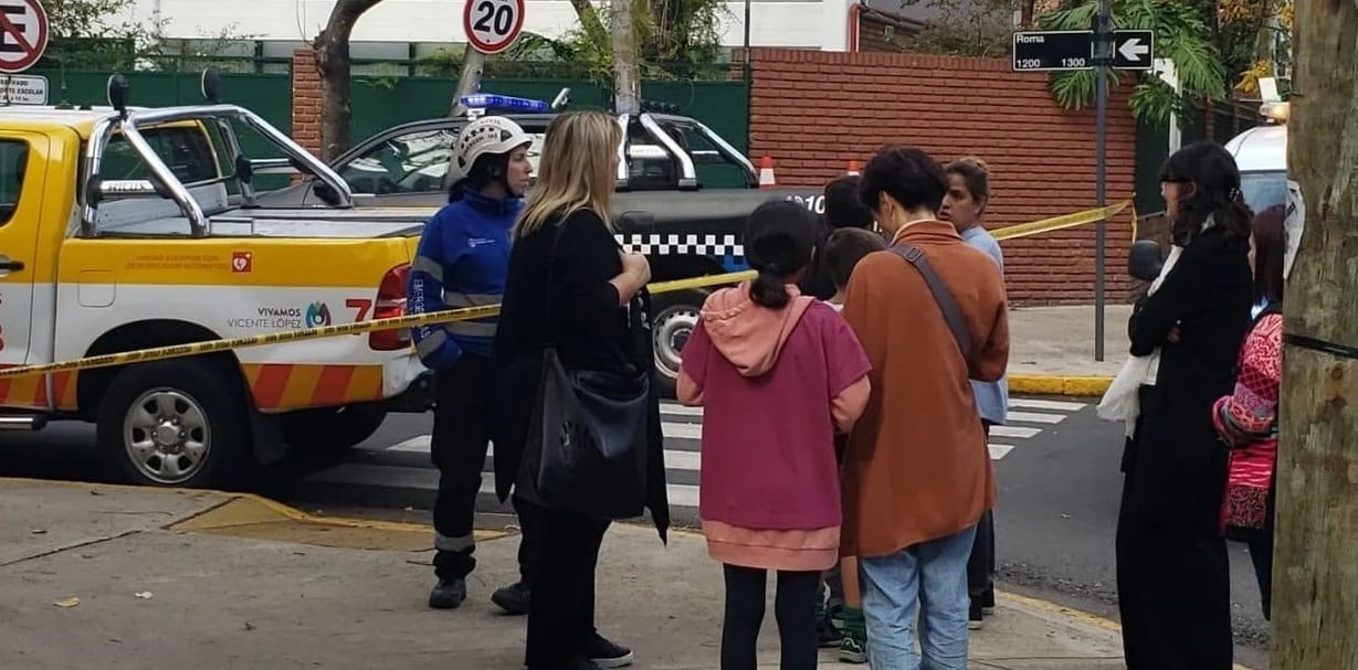 Padres preocupados en las cercanías de un colegio amenazado. 