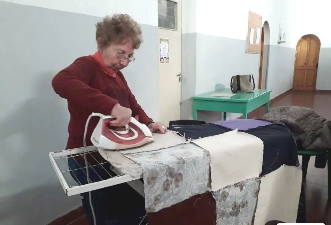 Las voluntarias de cáritas confeccionan acolchados para donar a familias vulnerables.