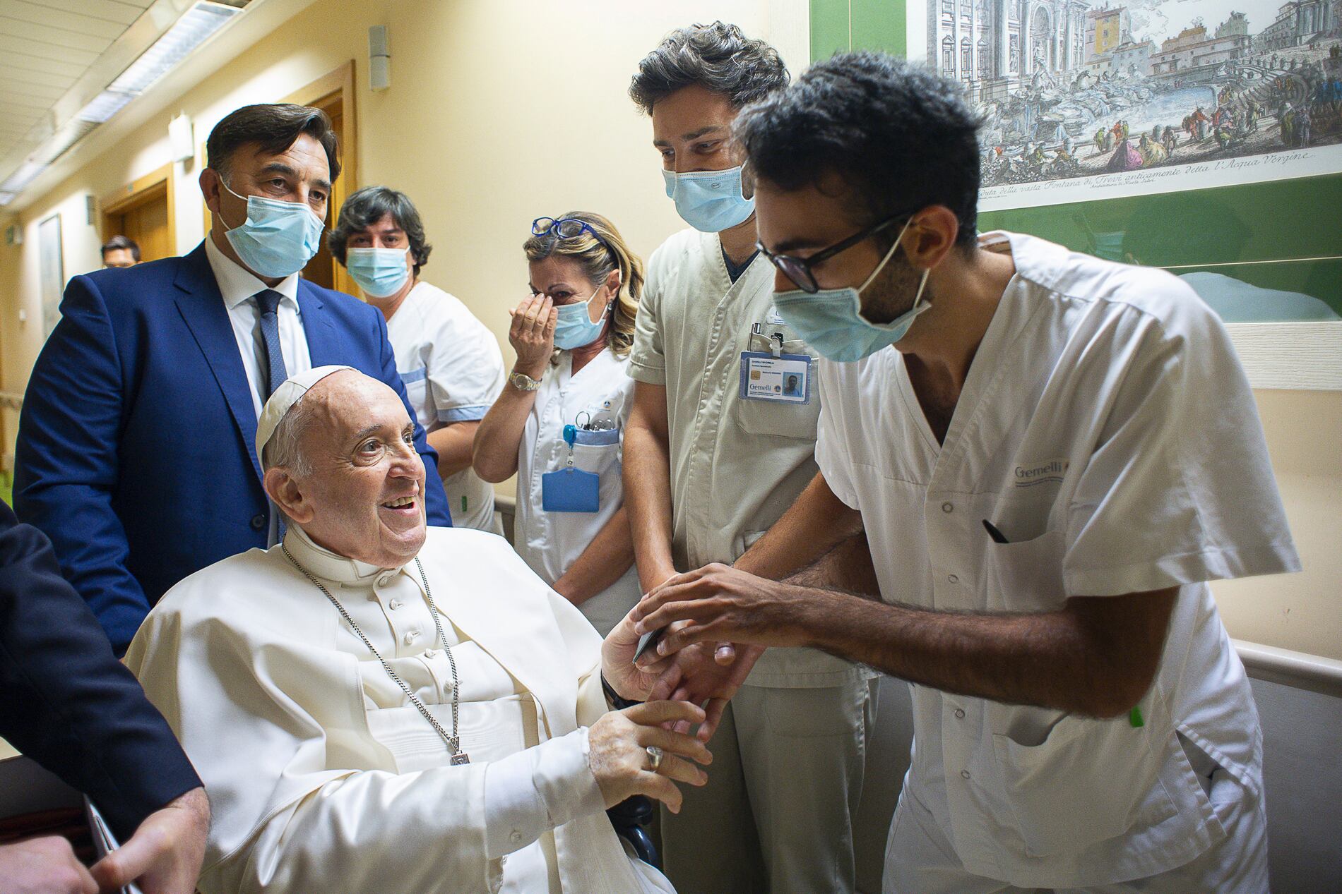 En esta imagen de archivo, el papa Francisco es recibido por el personal hospitalario a su entrada, en silla de ruedas, en el policlínico universitario Agostino Gemelli en Roma, el 11 de julio de 2021, antes de someterse a una operación intestinal. (Vatican Media vía AP, archivo)