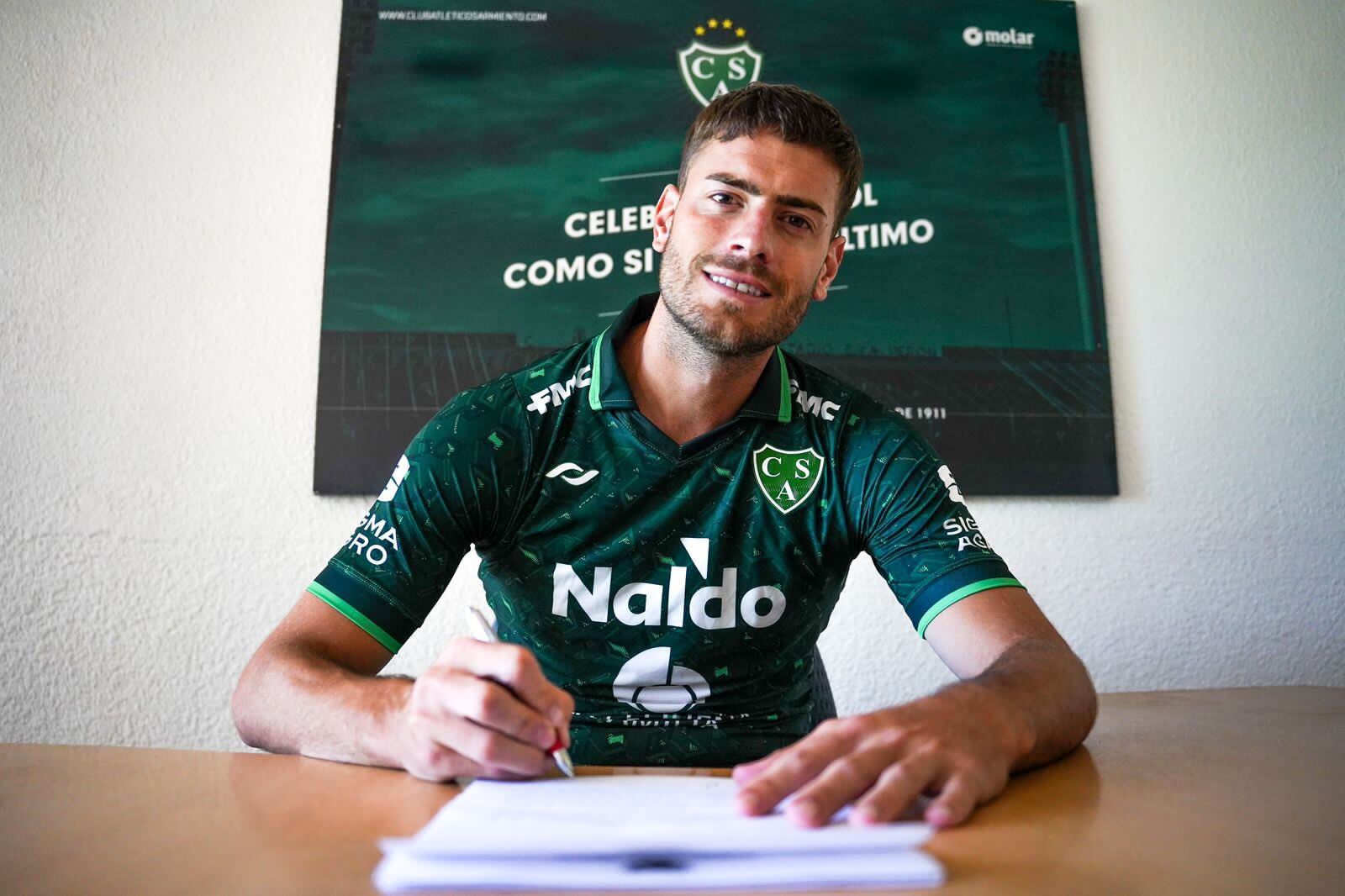 Lucas Melano y su firma para ser jugador de Sarmiento de Junín. (Prensa Sarmiento).