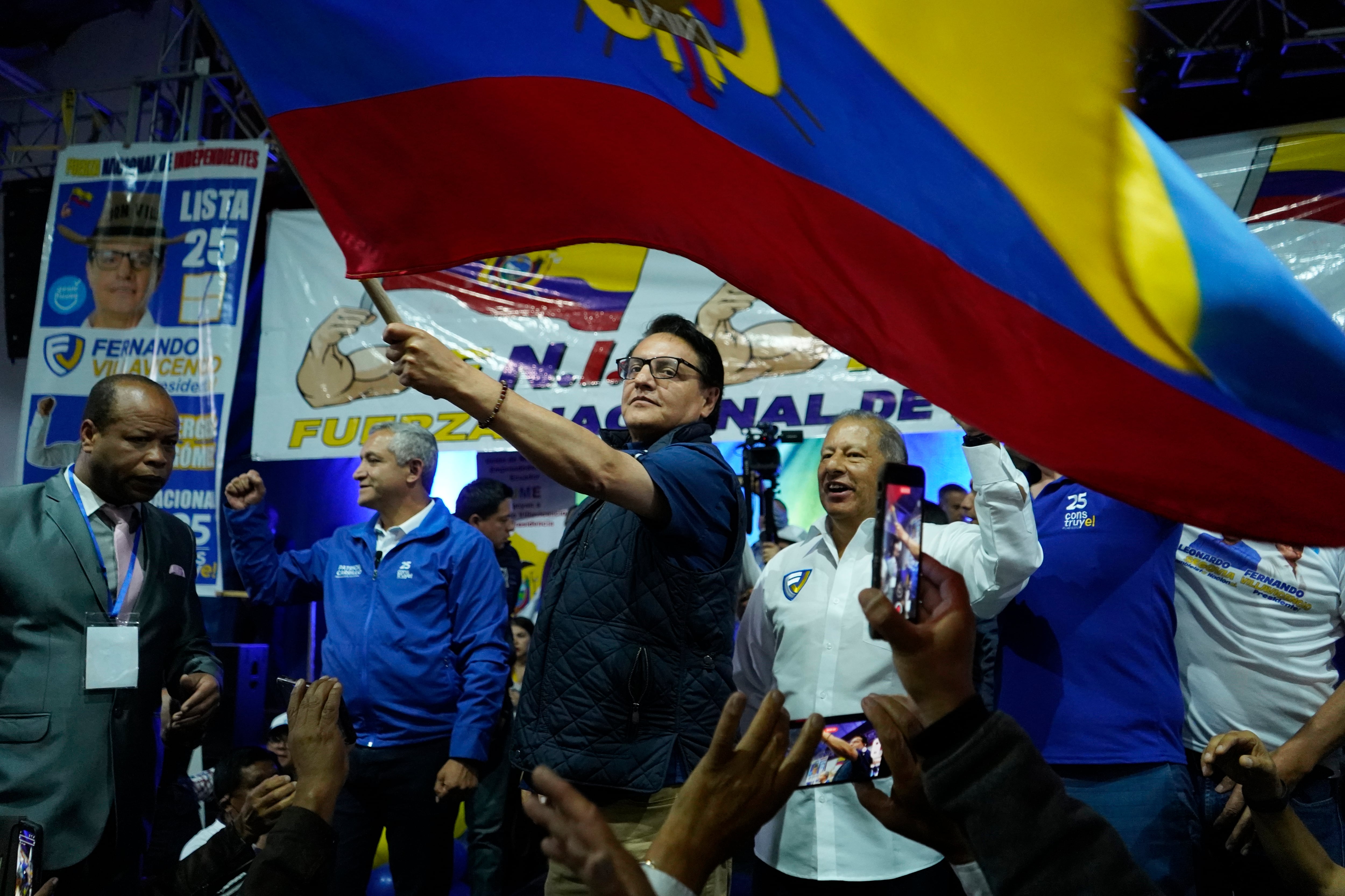 ARCHIVO - El candidato presidencial Fernando Villavicencio ondea una bandera nacional durante un evento de campaña en una escuela minutos antes de que lo mataran a tiros en Quito, Ecuador, el 9 de agosto de 2023. (AP vía AP/Archivo)