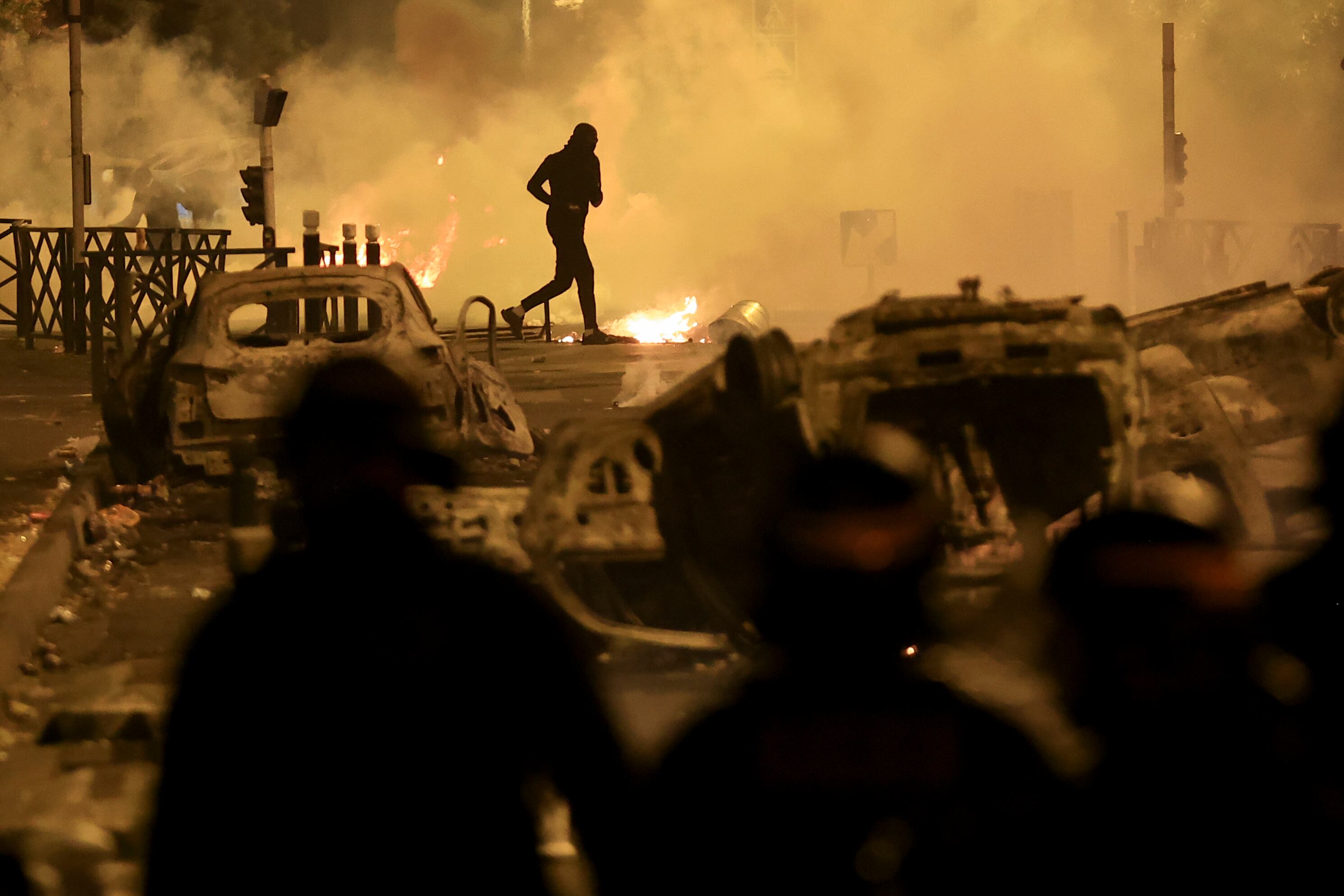 Un manifestante corre por una calle durante la tercera noche de protestas luego de la muerte de un conductor de 17 años por un disparo de la policía, en Nanterre, un suburbio de París, Francia, el 30 de junio de 2023. (AP Foto/Aurelien Morissard)