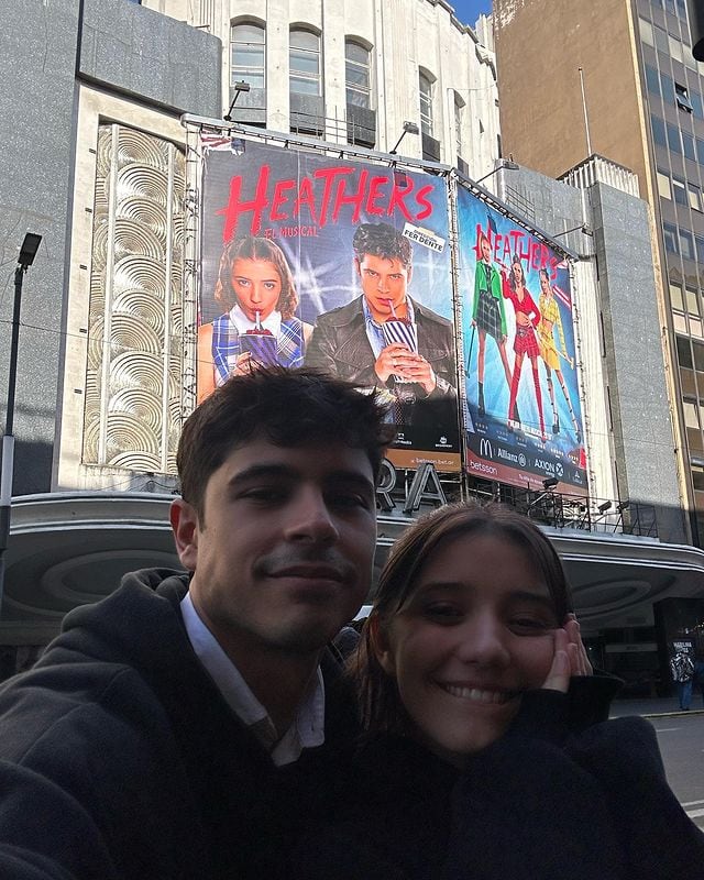 Nicolás Di Pace y Julia Tozzi frente al Teatro Ópera con la marquesina de Heathers, el musical