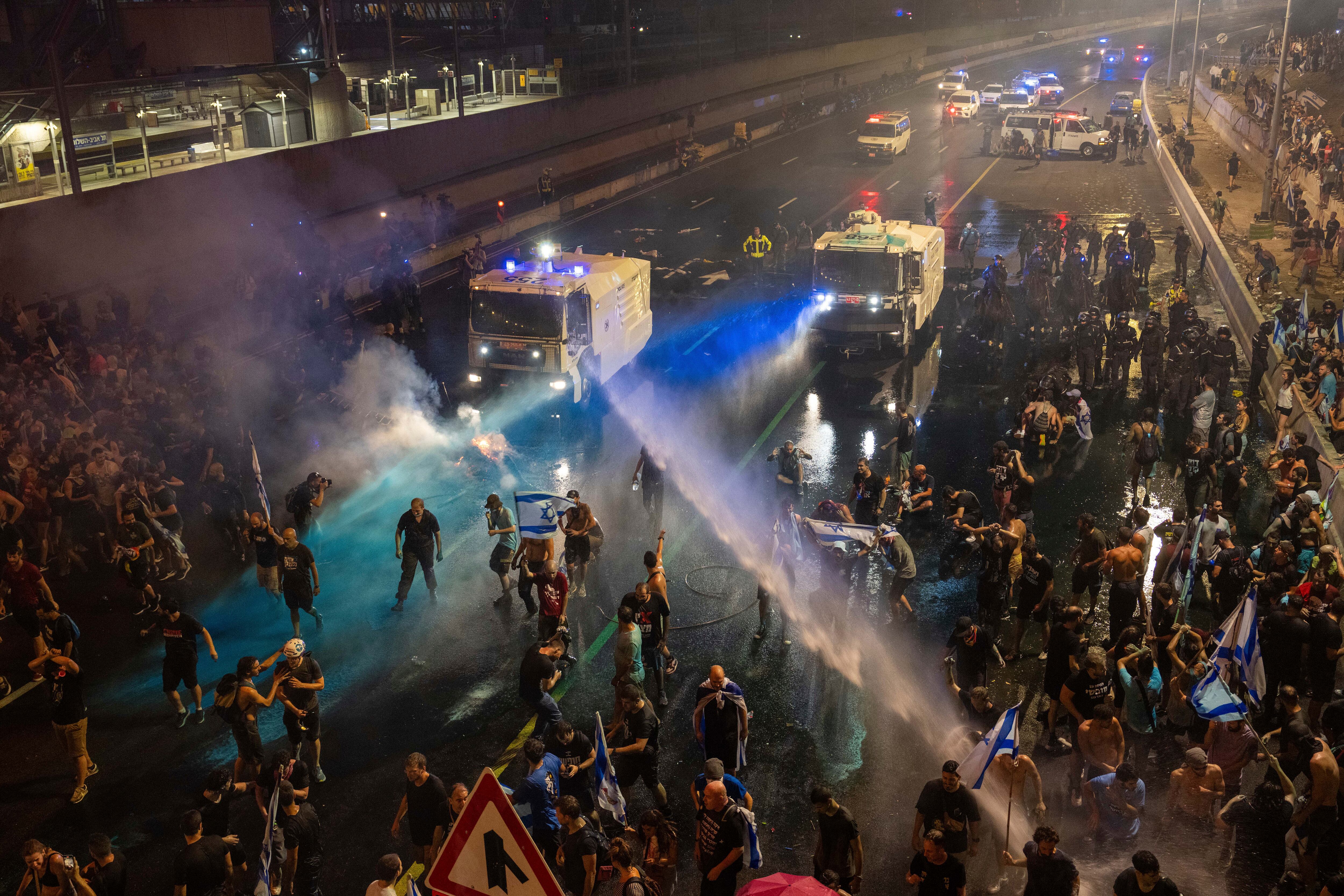 La policía antimotines intenta dispersar a manifestantes con un cañón hidrante durante una protesta contra el plan del gobierno de Benjamin Netanyahu de reformar el sistema judicial, en Tel Aviv, 24 de julio de 2023. Foto: AP / Oded Balilty.