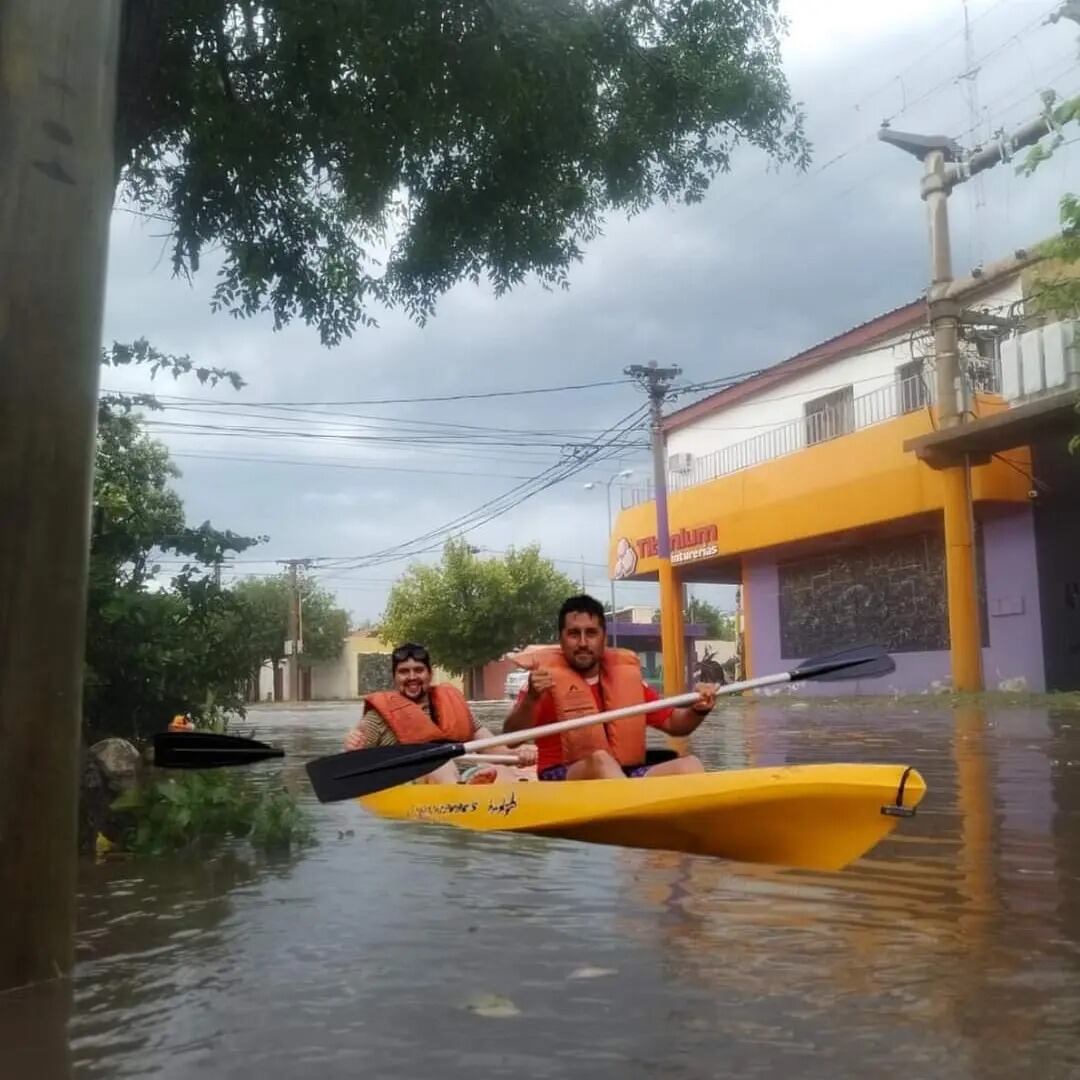 Vecinos en canoas ante la anegación de las calles.