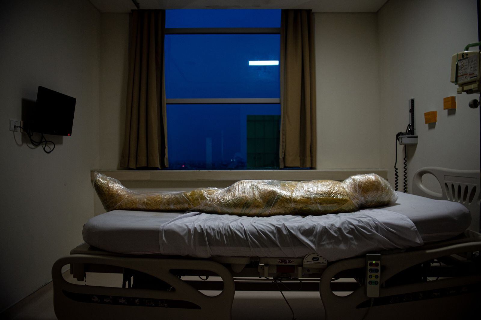La imagen pertenece al fotógrafo Joshua Irwandi y muestra a un cuerpo totalmente envuelto en plástico, sobre la cama de un hospital de Indonesia. El cadáver sería de una presunta víctima de Covid-19, una de las tantas que acumula ese país asiático.