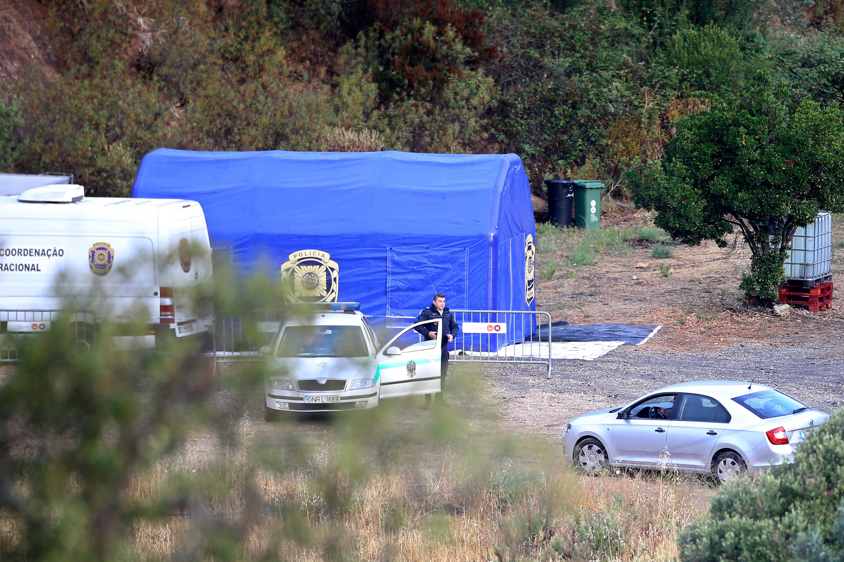 Un agente de policía, junto a un auto en una tienda de campaña habilitada para un operativo de búsqueda Madeleine McCann, la niña británica desaparecida en Algarve en 2007, cerca de Barragem do Arade, Portugal, el 23 de mayo de 2023. (AP Foto/Joao Matos)