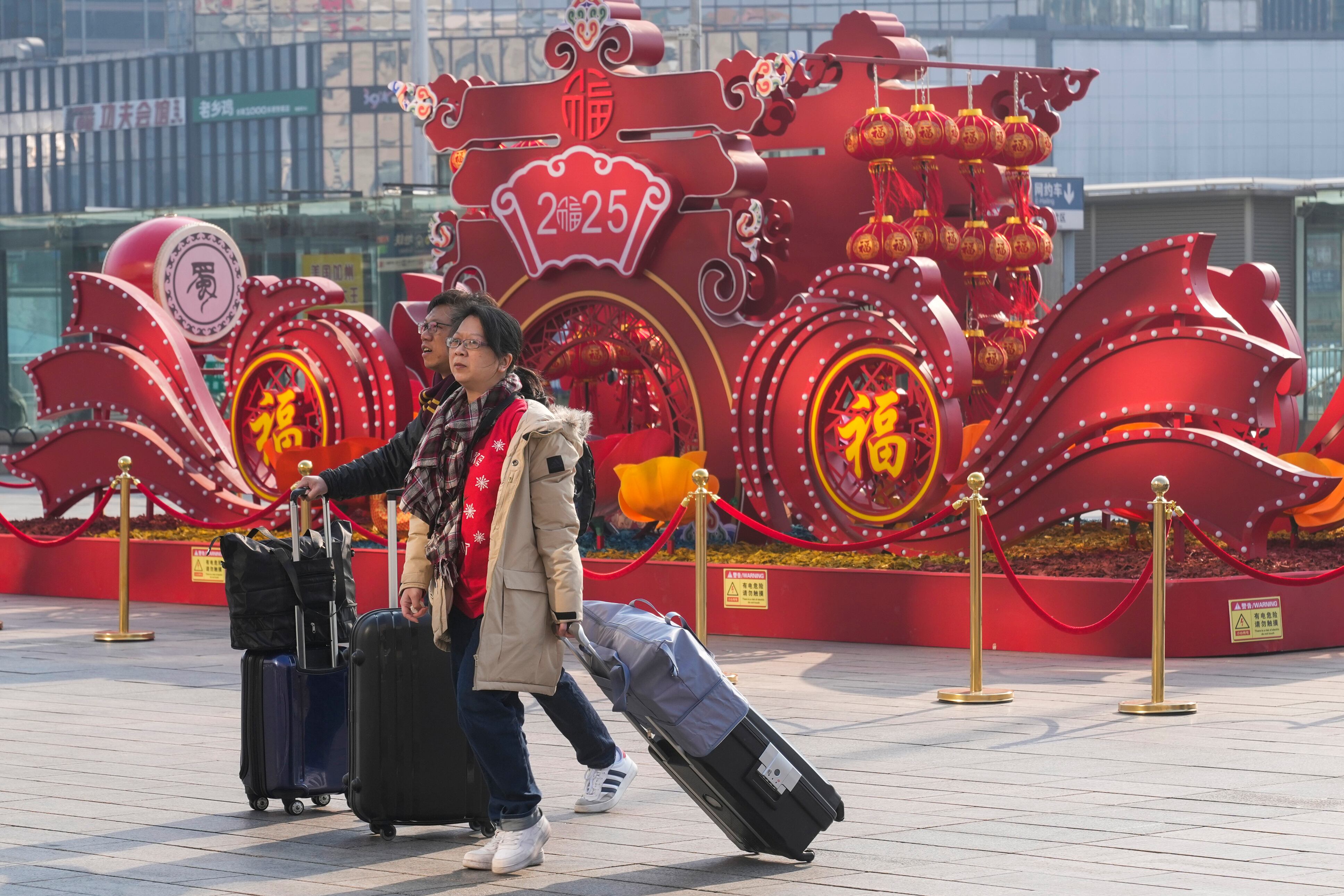 Viajeros caminan hacia la sala de salidas para tomar sus trenes el viernes 24 de enero de 2025 en una estación de Beijing, previo a que inicien las festividades por el Año Nuevo Lunar chino. (AP Foto/Aaron Favila)