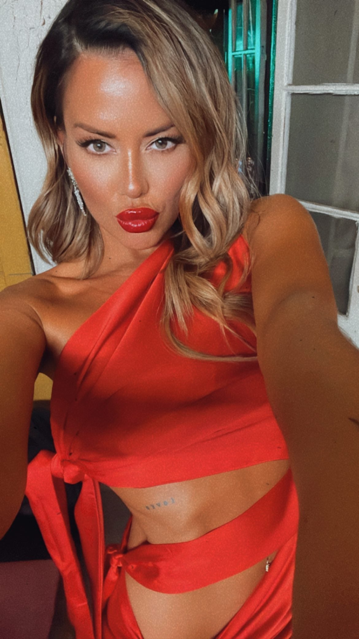 Karina Jelinek y unas fotografías a puro fuego: vestido rojo al cuerpo y aberturas en sus costados.