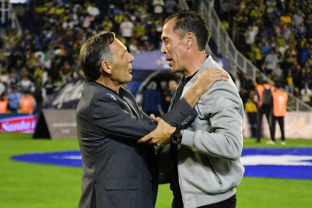 Lucas Bovaglio se saluda con Miguel Ángel Russo, durante el partido entre Rosario Central e Instituto. (Fotobaires)