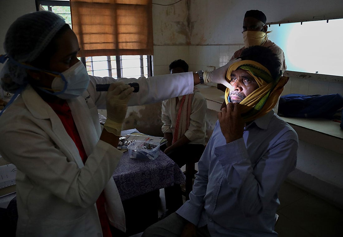 Un médico indio revisa a un hombre que se recuperó del COVID-19 y ahora está infectado con un hongo negro en la sala de mucormicosis de un hospital gubernamental en Hyderabad, India, el jueves 20 de mayo de 2021.