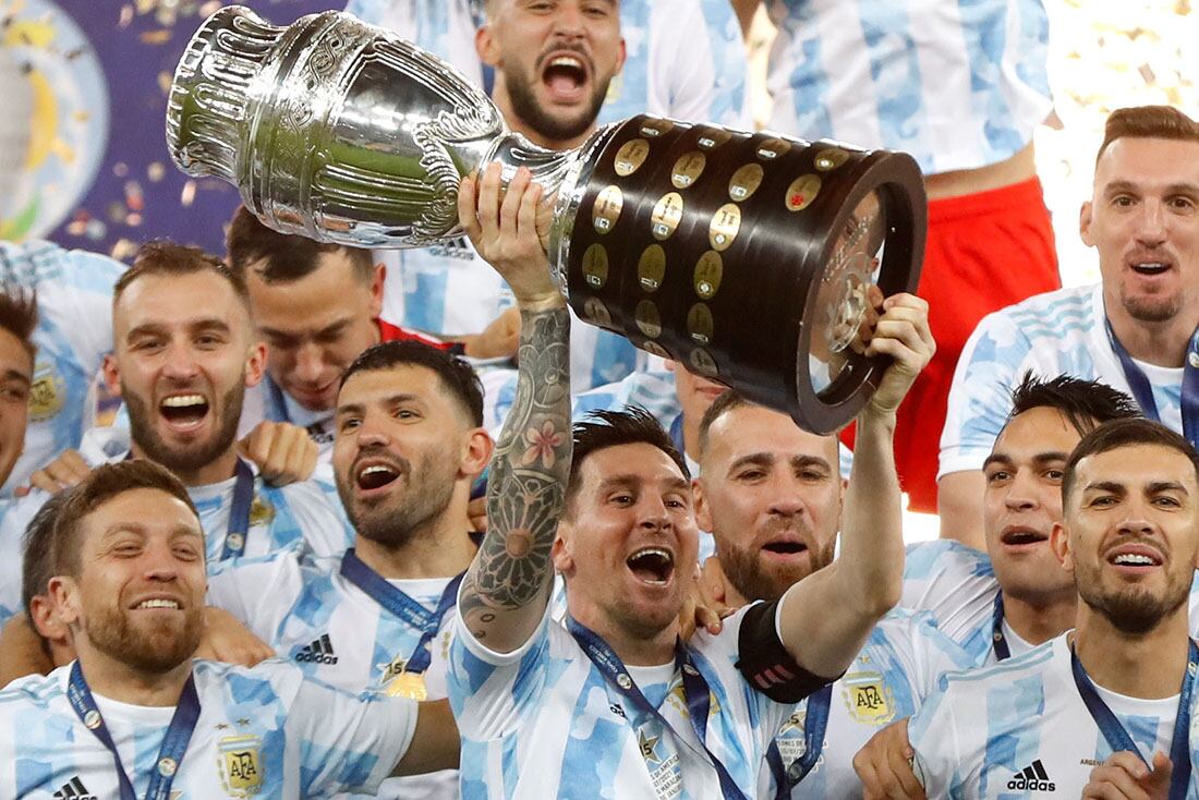 Argentina's Lionel Messi holds the trophy as he celebrates with the team after beating 1-0 Brazil in the Copa America final soccer match at the Maracana stadium in Rio de Janeiro, Brazil, Saturday, July 10, 2021.