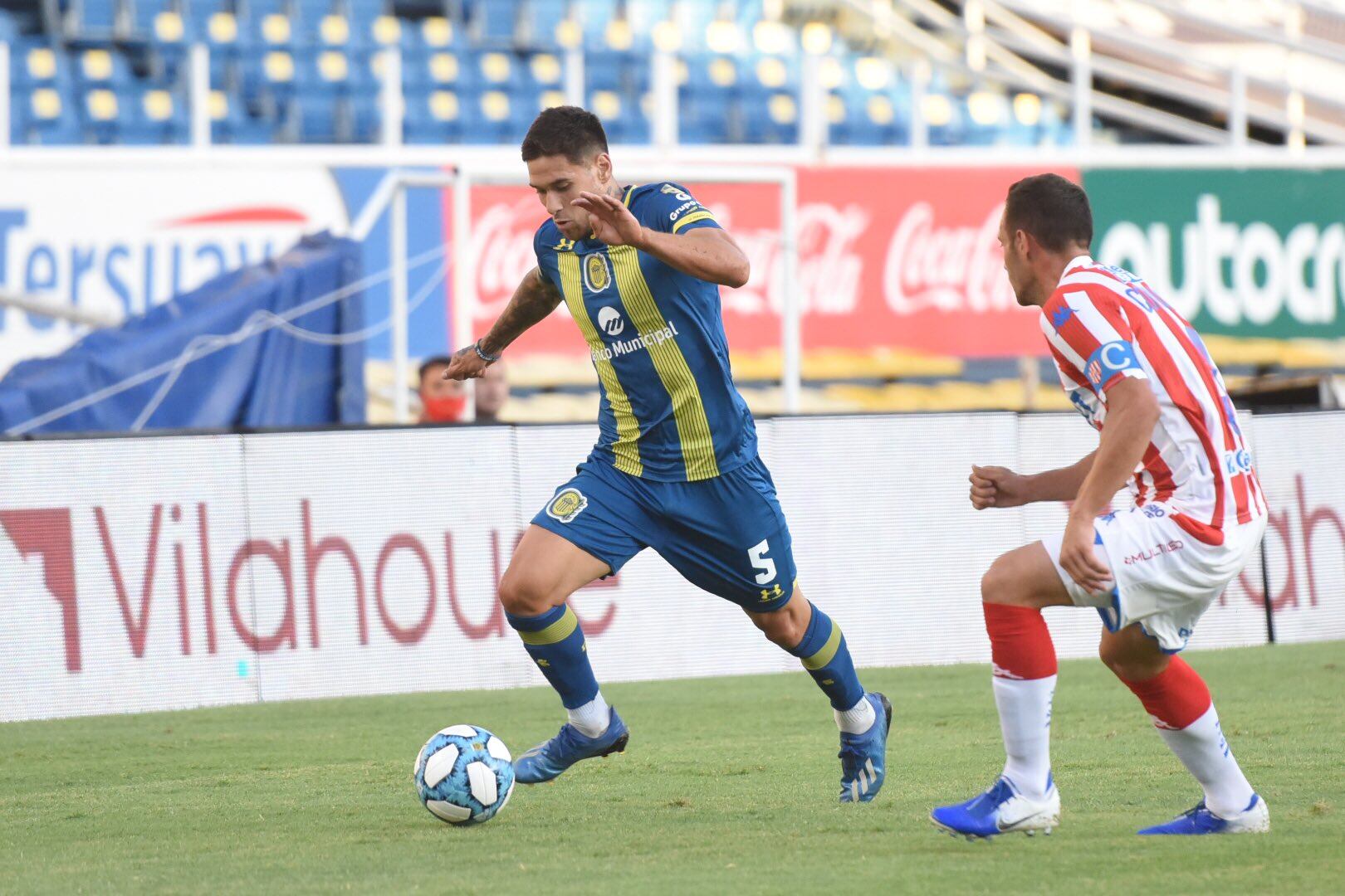 El volante Rodrigo Villagra lleva la pelota ante la marca de Claudio Corvalán en el partido entre Rosario Central y Unión de Santa Fe. (@carcoficial)