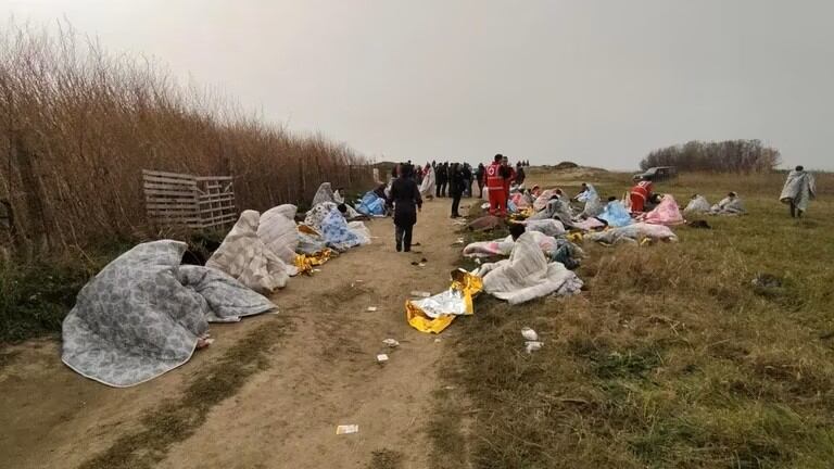 Un grupo de personas es asistido por los servicios de emergencia en una playa cerca de Cutro, provincia de Crotone. Foto: Giuseppe Pipita/EFE.