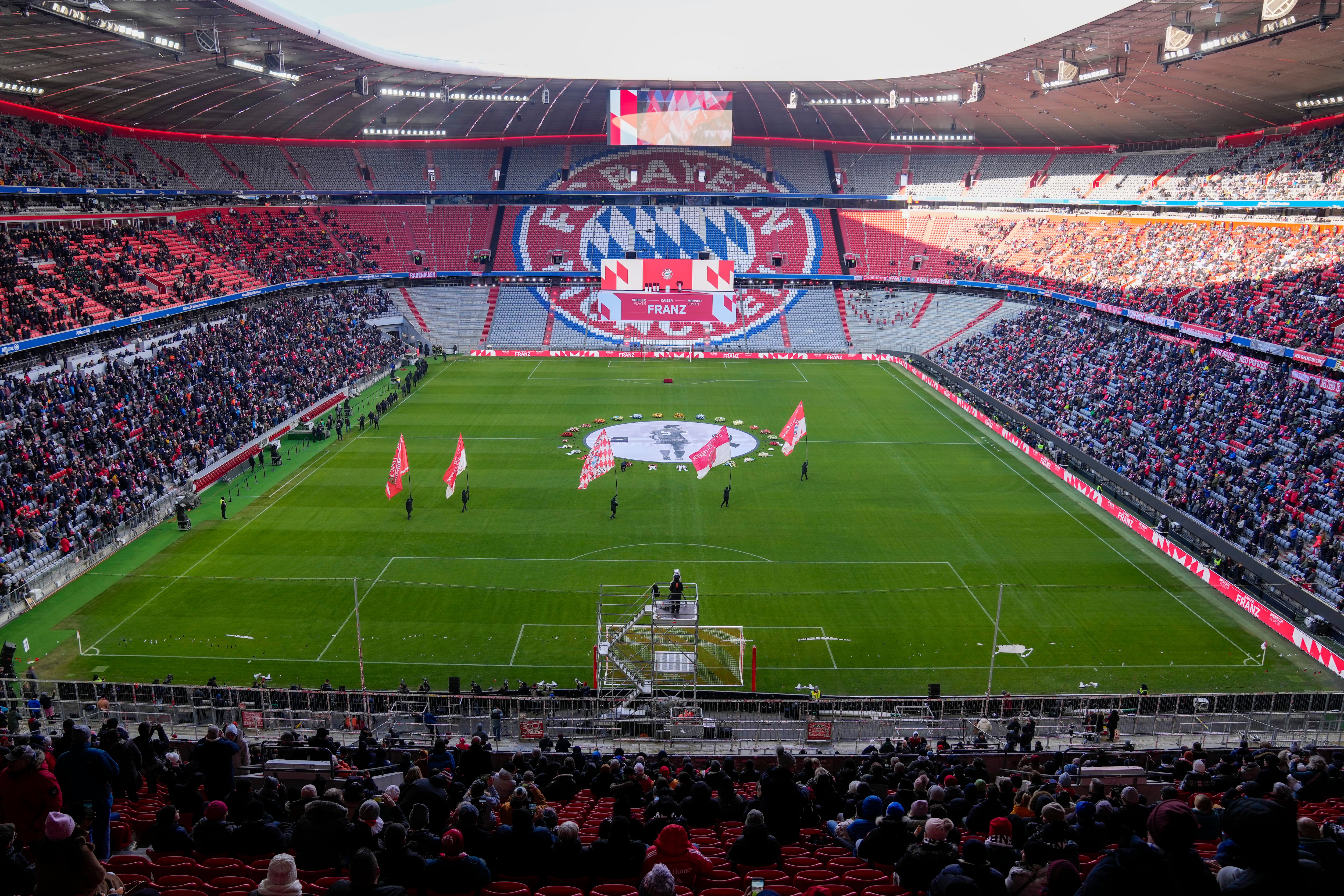 ARCHIVO - En foto del 19 de enero del 2024, colocan guirnaldas de flores rodeando una fotografía de Franz Beckenbauer en el Allianz Arena. El jueves 19 de septiembre del 2024, nombrarán la plaza que rodea al estadio, Franz Beckenbauer. (AP Foto/Matthias Schrader, Archivo)