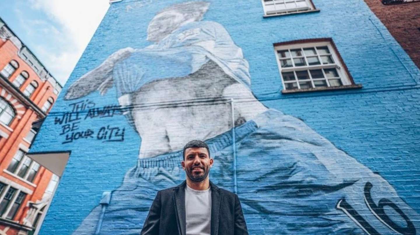 El "Kun" junto a su mural. (Foto: Web)