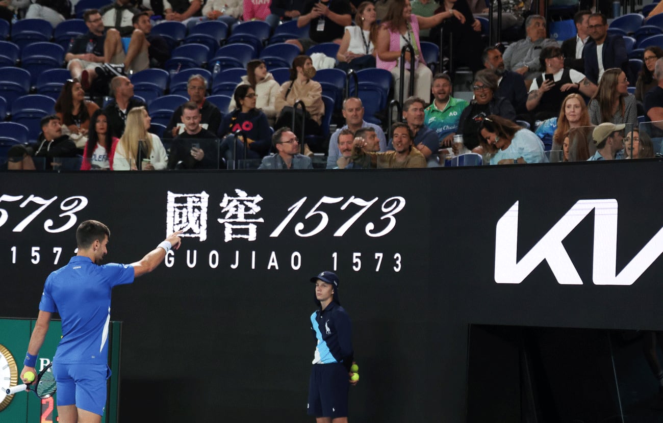 Djokovic se acerca a la tribuna para responderle a un espectador que le gritó durante todo el partido frente al local Alexei Popyrin. (AP)