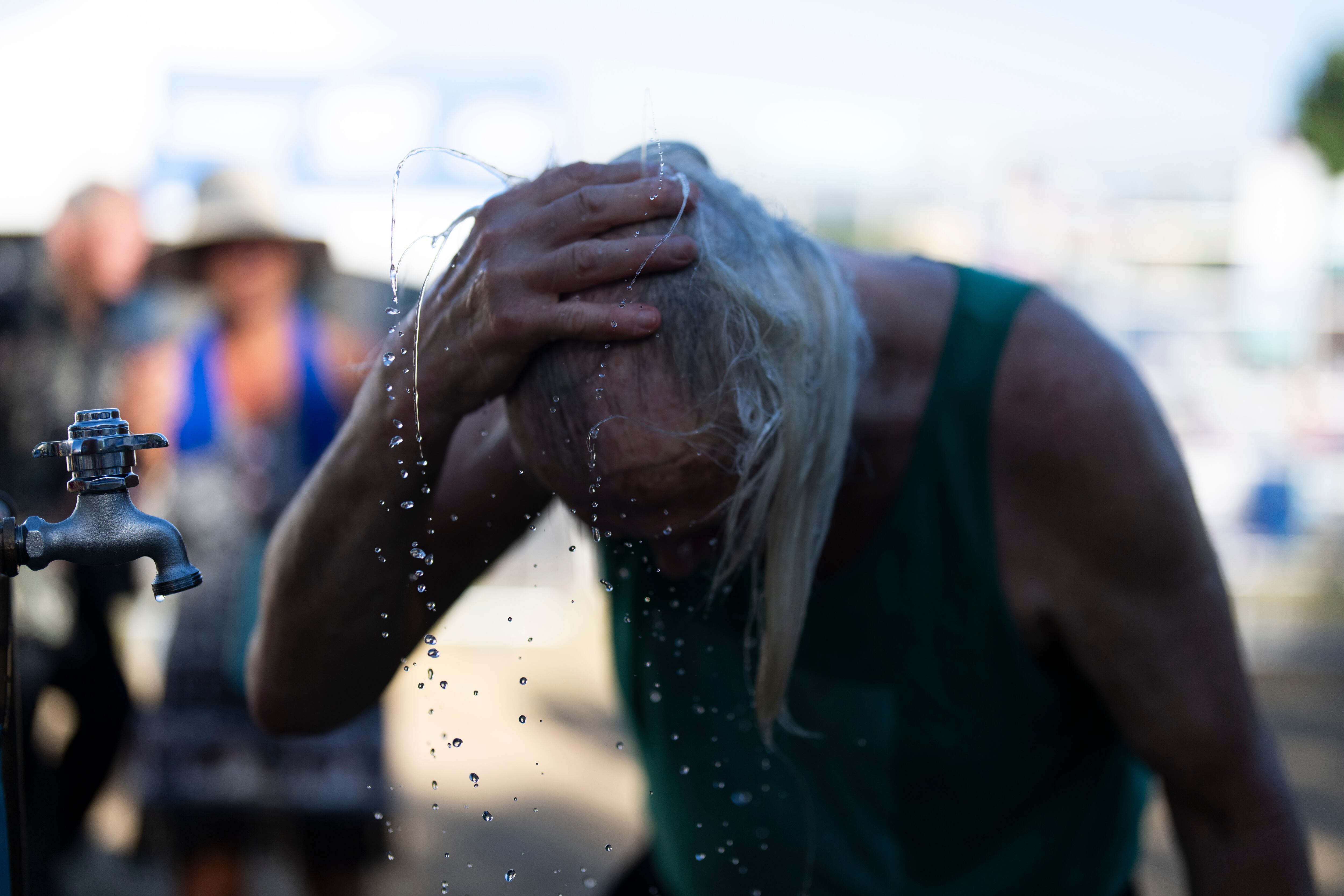 Una persona se refresca durante el festival de blues de Waterfront, el viernes 5 de julio de 2024, en Portland, Oregon. (AP Foto/Jenny Kane)