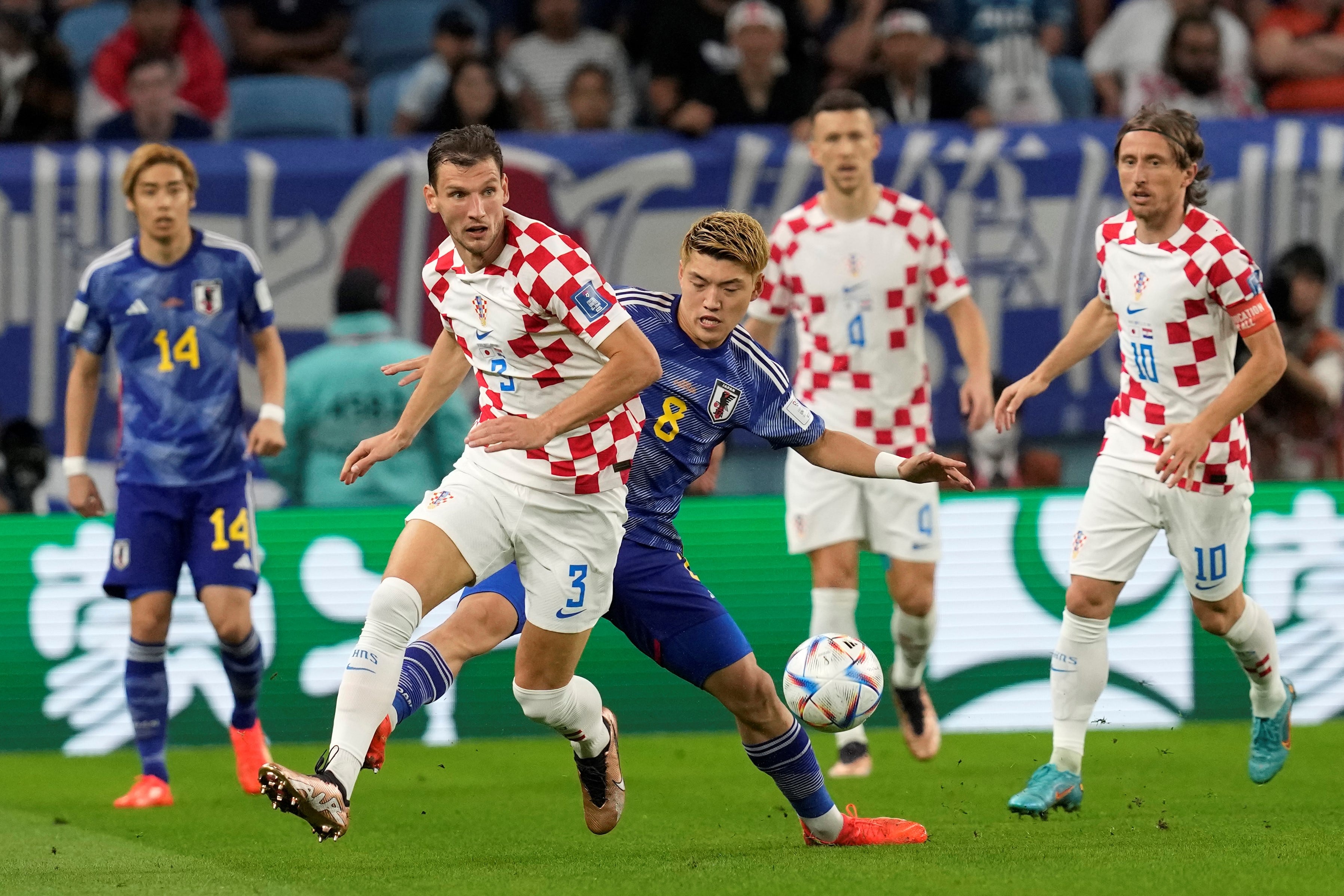 Barisic la defiende de Ritsu Doan. Croacia y Japón se enfrentan en el estadio Al Janoub de Al Wakrah. (AP Photo/Thanassis Stavrakis)