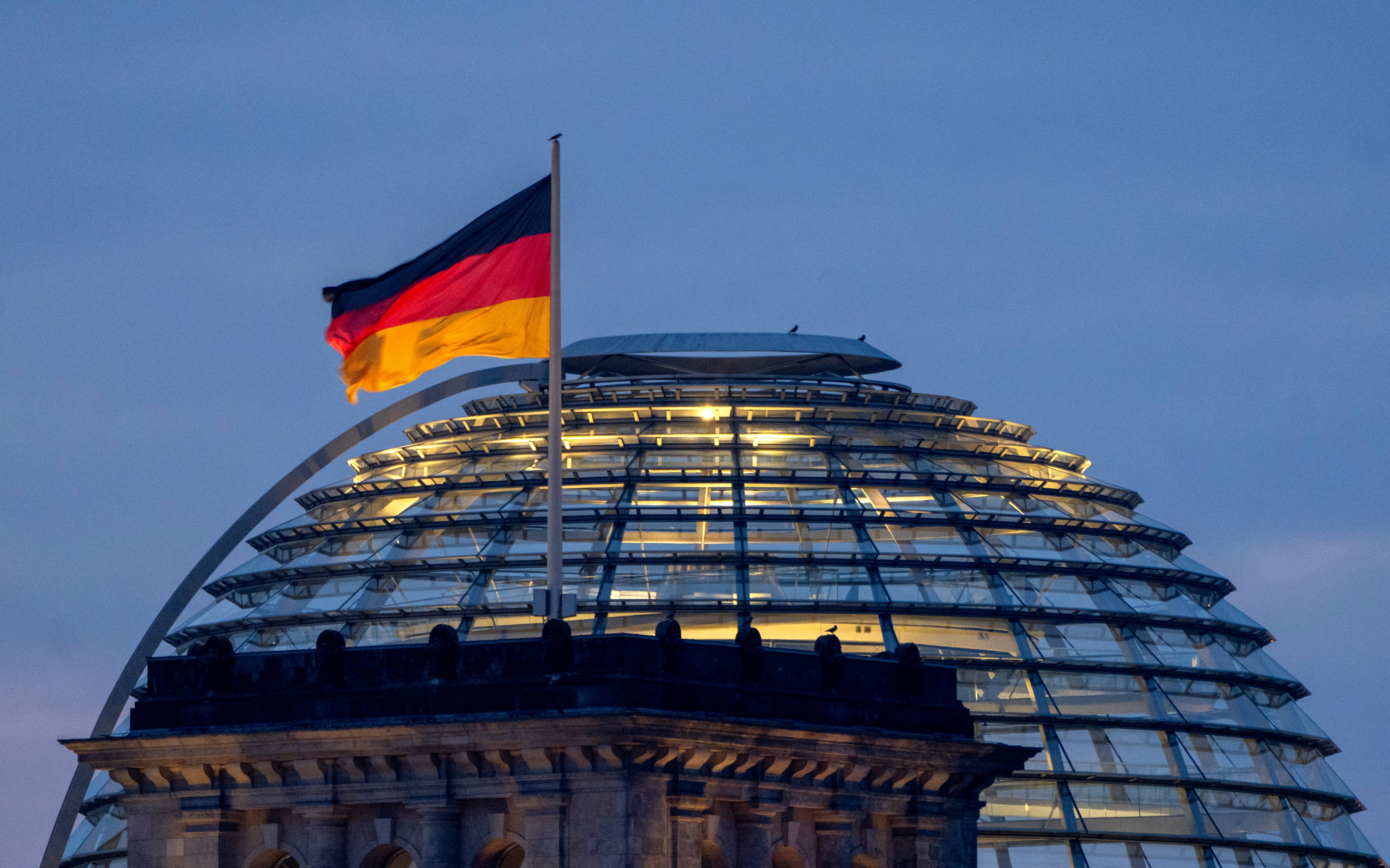 Una bandera alemana ondea sobre el edificio del Reichstag en Berlín, Alemania, el domingo 23 de febrero de 2025. (AP Foto/Michael Probst)