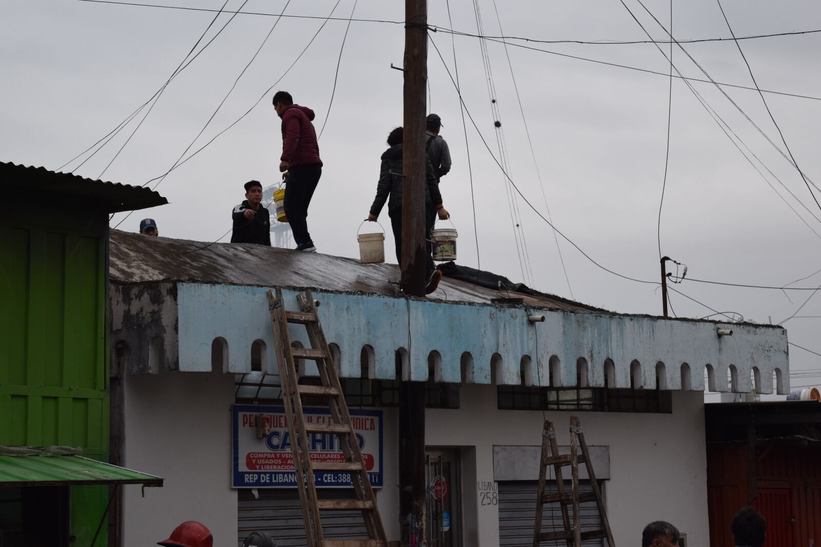 Los puesteros se sumaron a la tarea de los bomberos, acarreando agua por los techos de la feria.