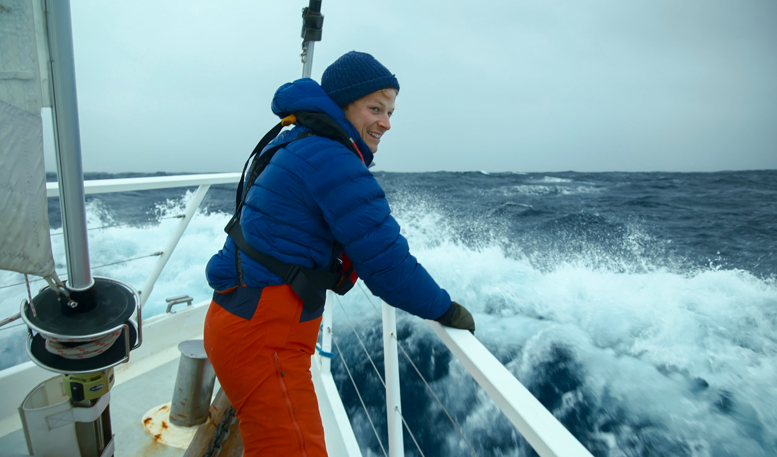 Bertie Gregory on board the Australis, looking over the edge of the ship. (credit: National Geographic for Disney+/Will West)