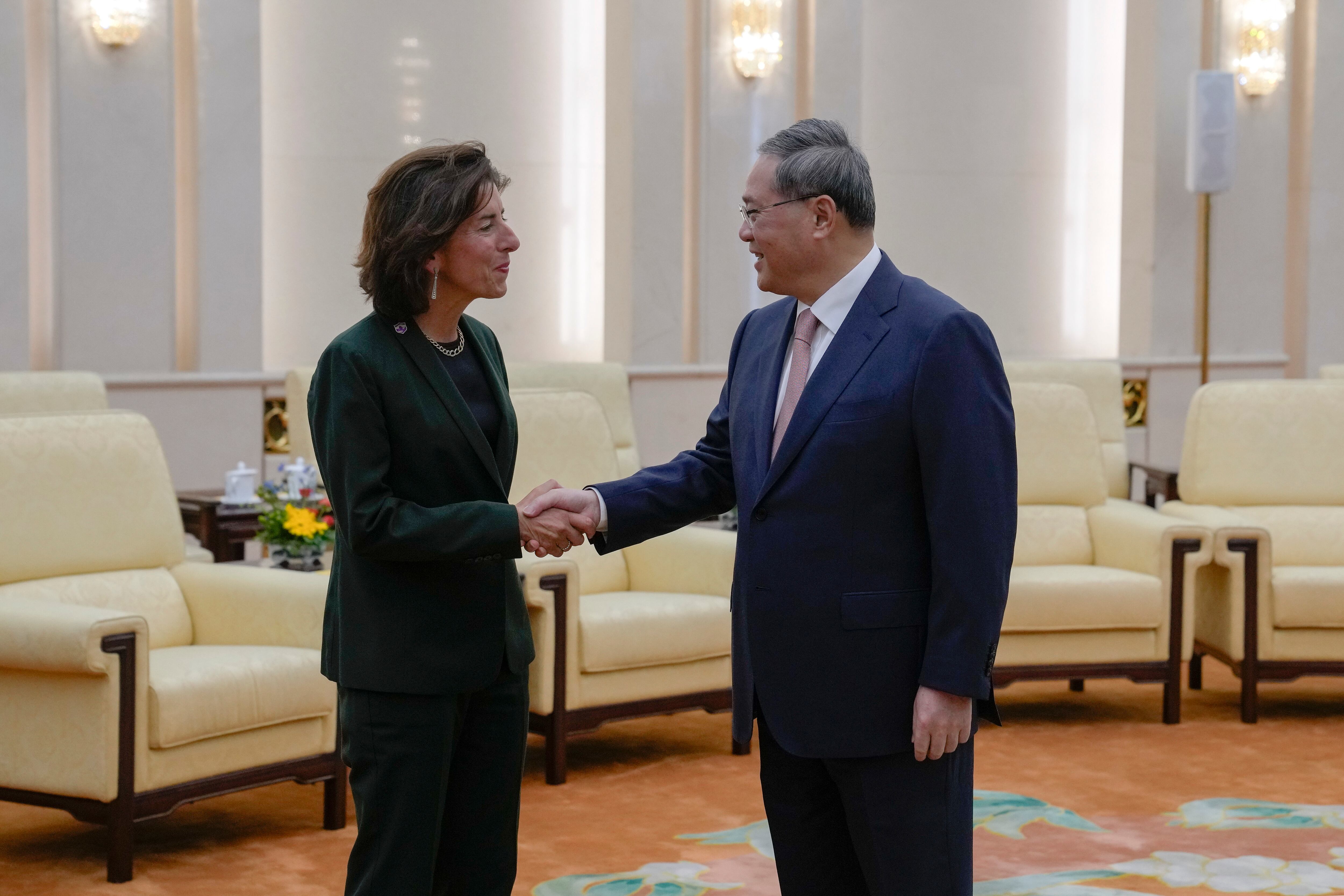 La secretaria de Comercio estadounidense, Gina Raimondo, izquierda, estrecha la mano del premier chino Li Quang en el Gran Salón del Pueblo en Beijing, martes 29 de agosto de 2023. (AP Foto/Andy Wong, Pool)