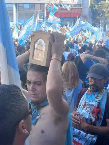 Mauricio Miguez con la urna que contiene las cenizas de su padre en los festejos de las calles de Comodoro.