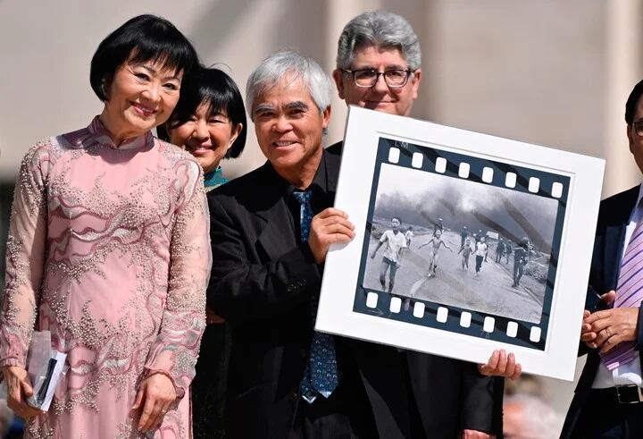 Nick Ut enseña la icónica foto junto a Kim Phuc.