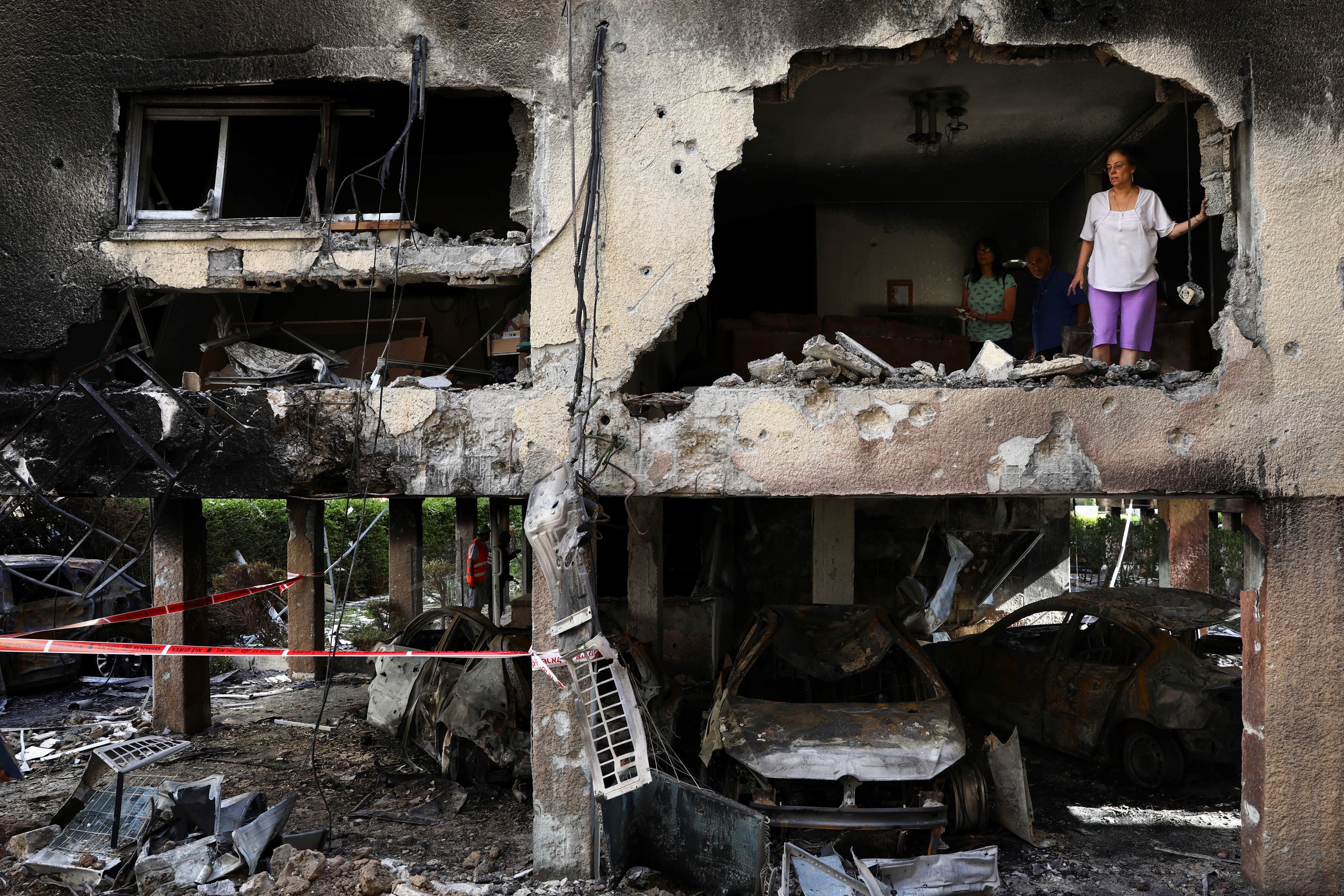 Miembros de una familia inspeccionan los daños de su departamento después de que fuera alcanzado por un cohete disparado desde la Franja de Gaza durante la noche en Petah Tikva, en el centro de Israel.