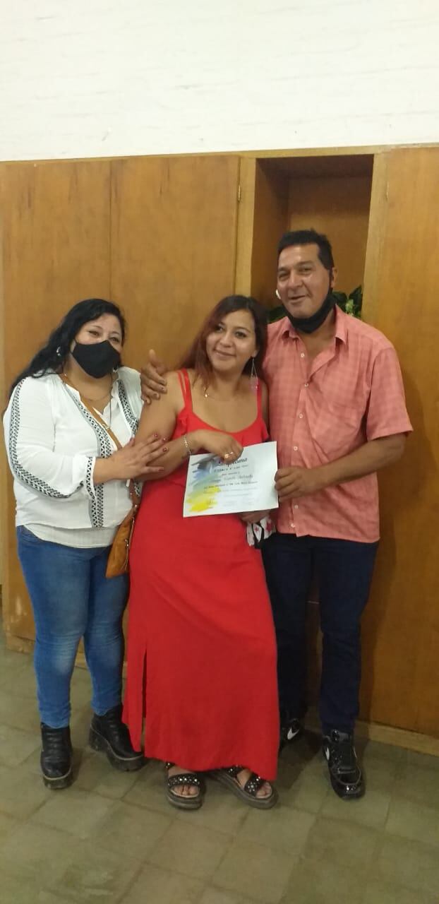 Antonella con papá y mamá luego de recibir la bandera.