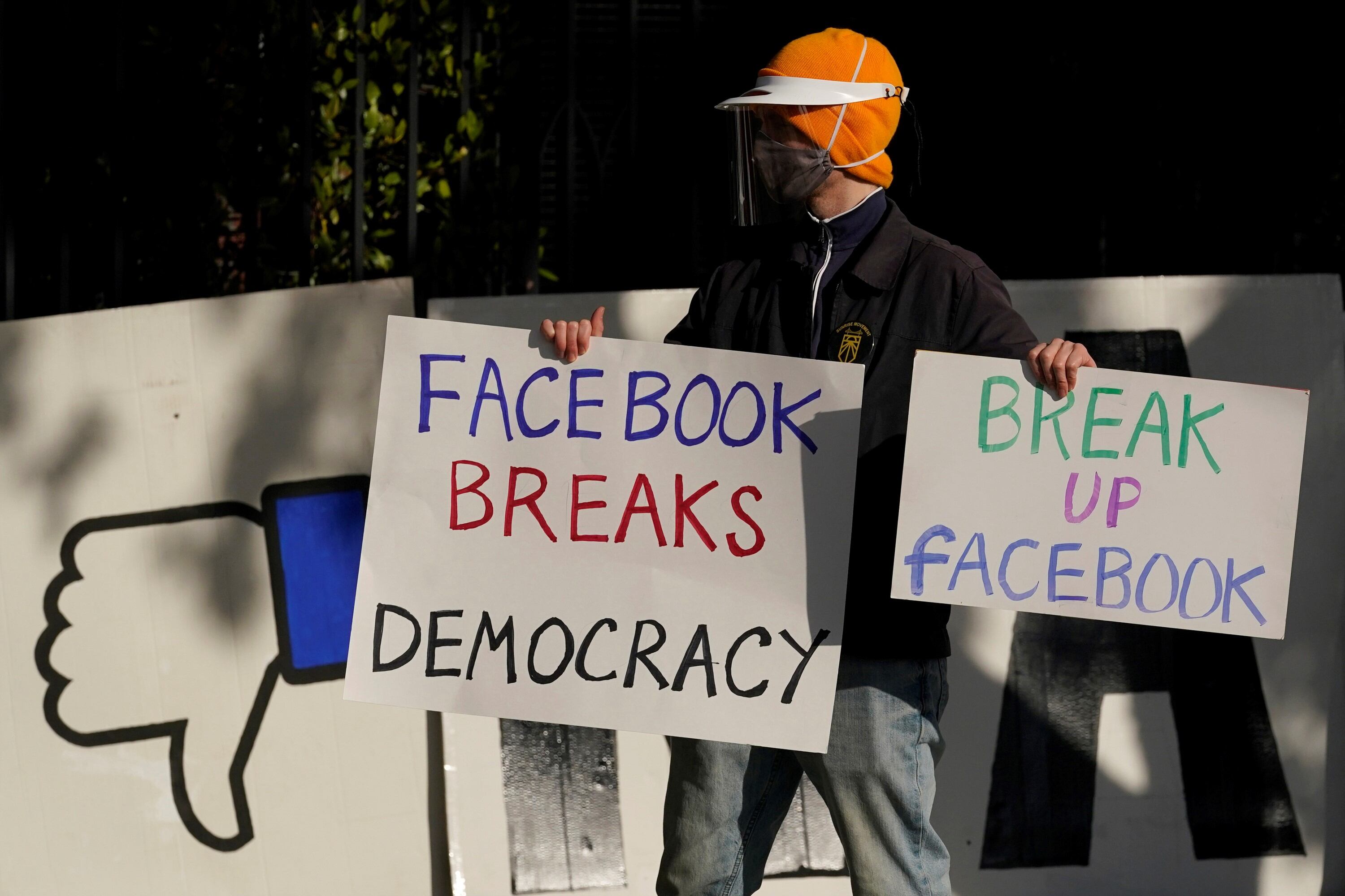 un manifestante se une a otros fuera de la casa del CEO de Facebook, Mark Zuckerberg, para protestar por lo que dicen que Facebook difunde desinformación en San Francisco.