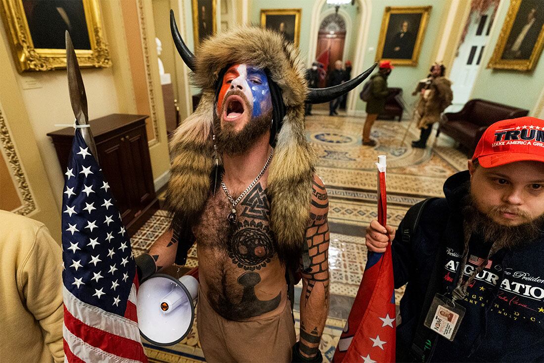 Jacob Anthony Chansley, centro, con otros insurrectos que apoyaron al entonces presidente Donald Trump, son confrontados por la Policía del Capitolio de los Estados Unidos en un pasillo fuera de la cámara del Senado