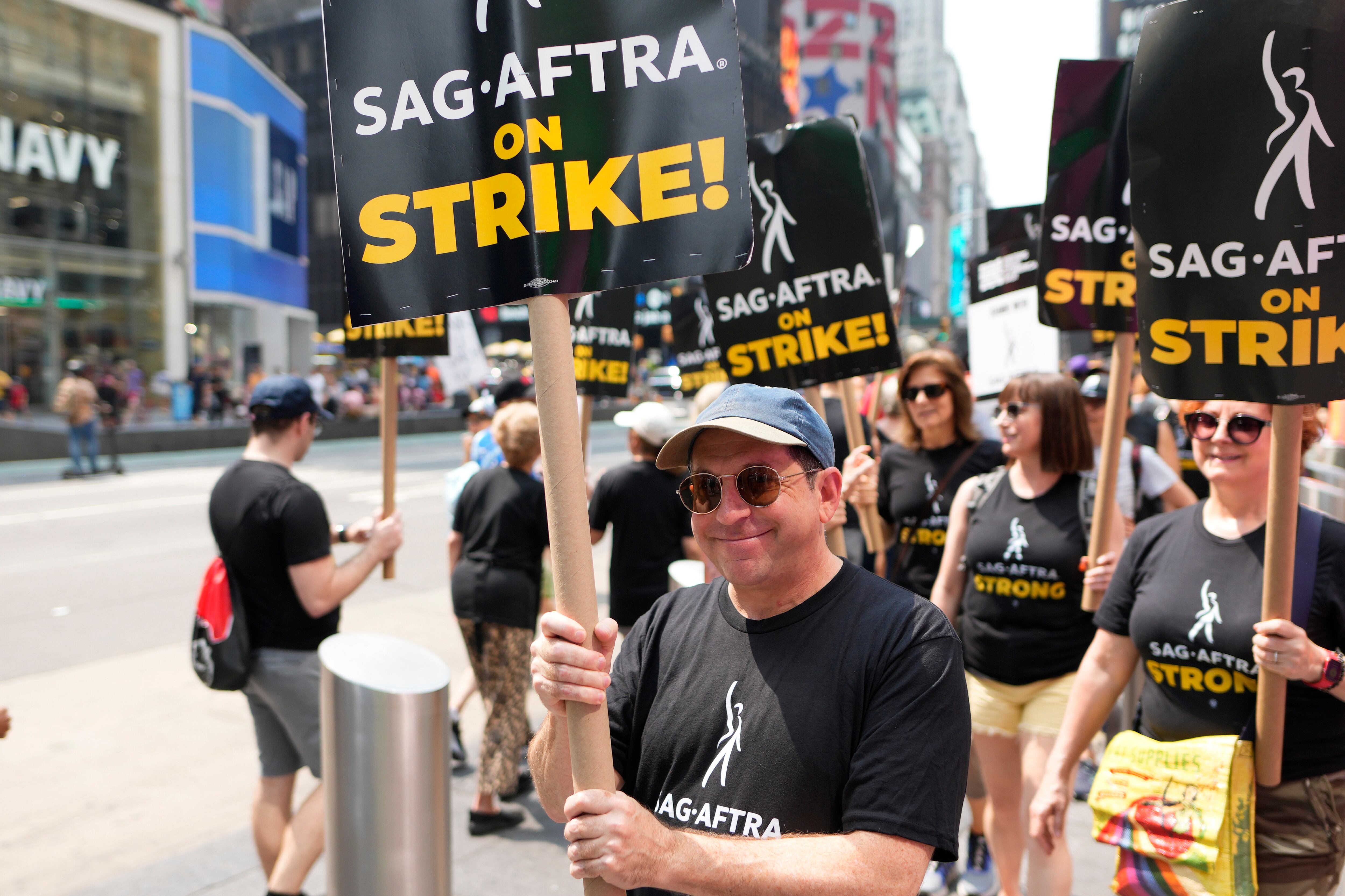 ARCHIVO - El actor Jason Kravits con un cartel en un mitin frente a Paramount en Times Square en Nueva York el 17 de julio de 2023. (Foto Charles Sykes/Invision/AP)