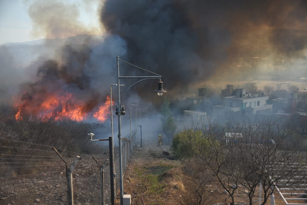 Fuego en Córdoba. Intenso trabajo de los bomberos para contener el incendio en el country La Cuesta, de La Calera. (Facundo Luque / La Voz)