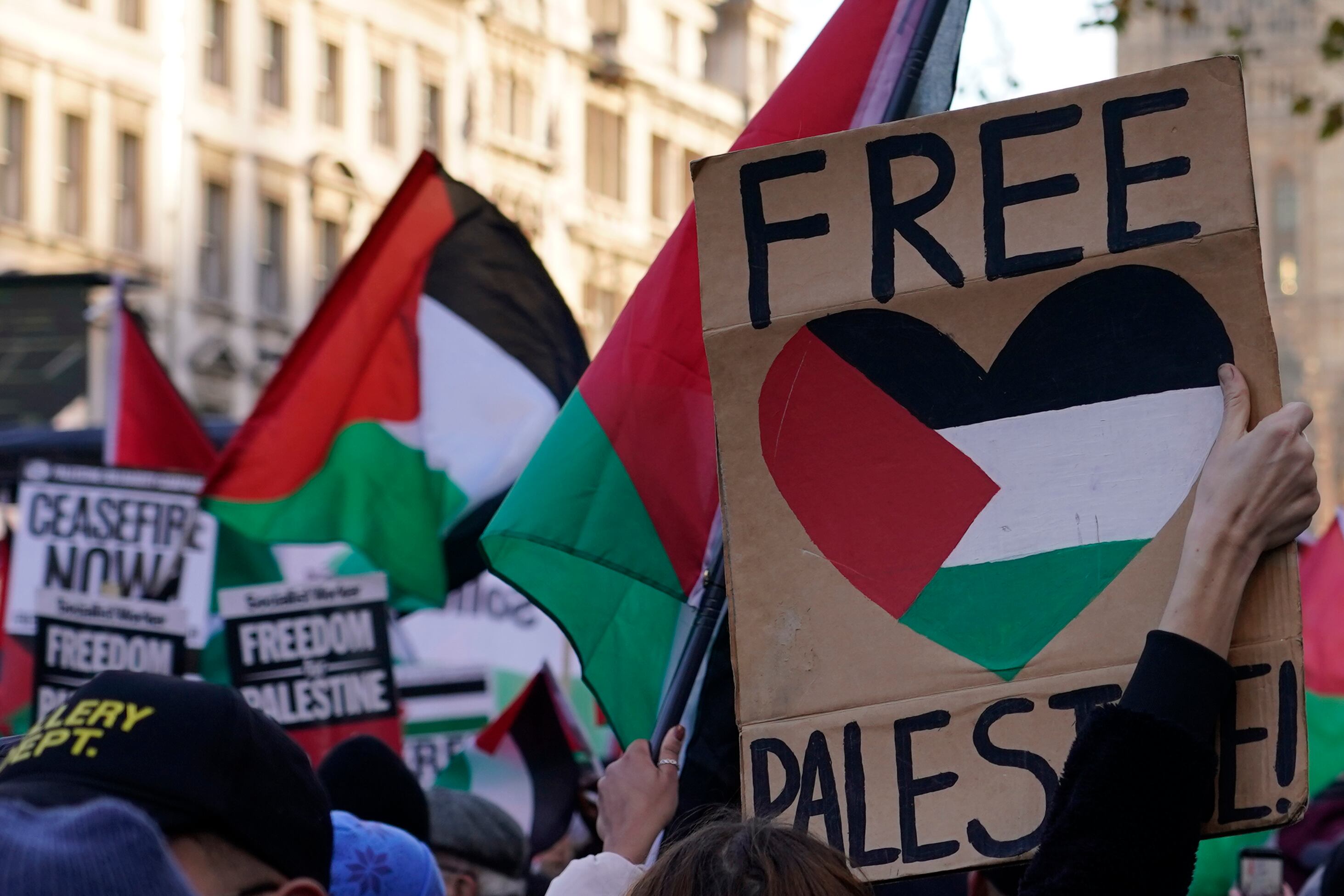 Manifestantes con banderas y pancartas realizan una manifestación propalestina en Whitehall, la calle de los edificios de gobierno en Londres, sábado 25 de noviembre de 2023.