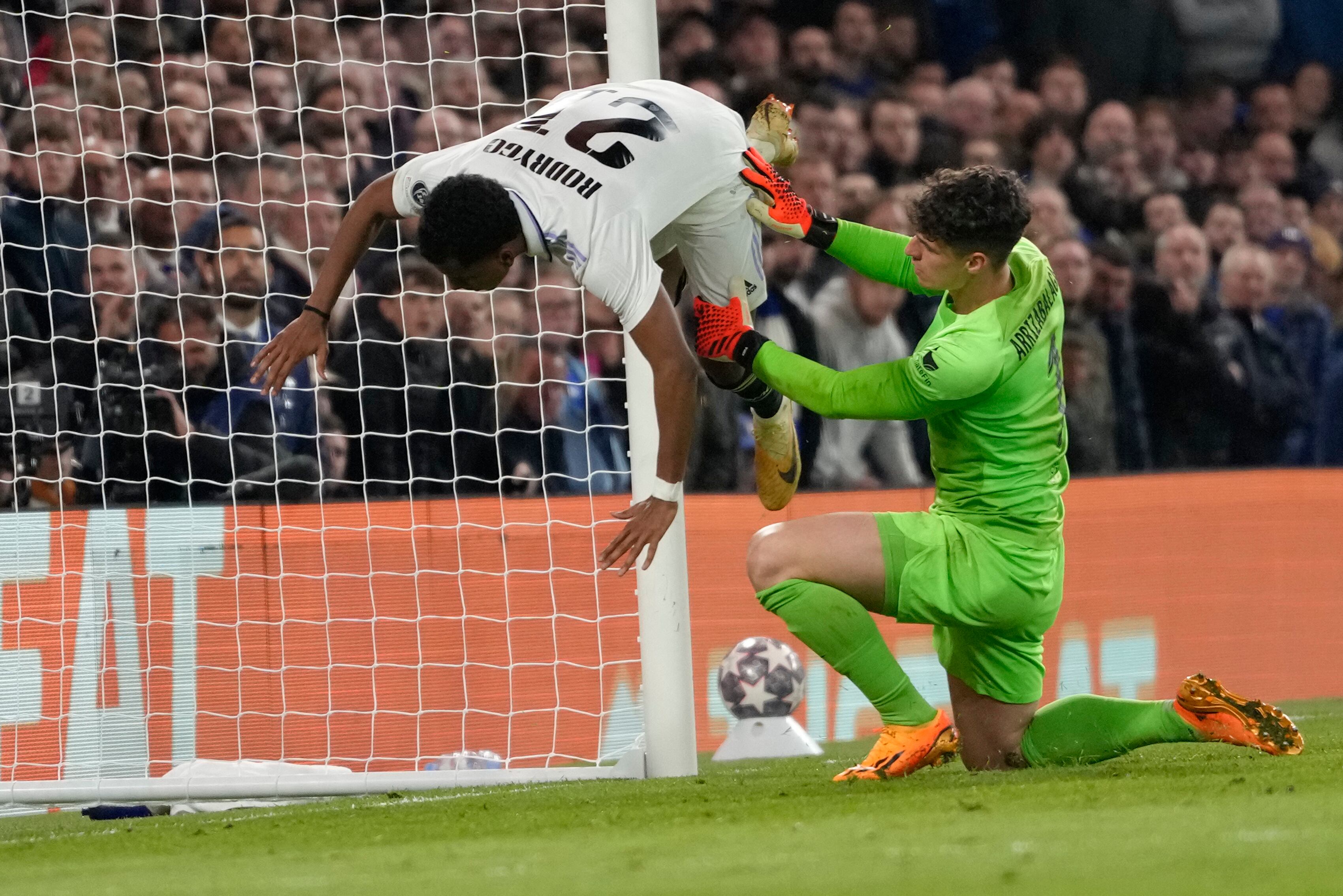 Rodrygo, del Real Madrid, izquierda, es derribado por el portero del Chelsea, Kepa Arrizabalaga, después de anotar el segundo gol de su equipo durante el partido de cuartos de final de la Liga de Campeones en el estadio Stamford Bridge, 18 de abril de 2023. (AP Foto/Kirsty Wigglesworth)