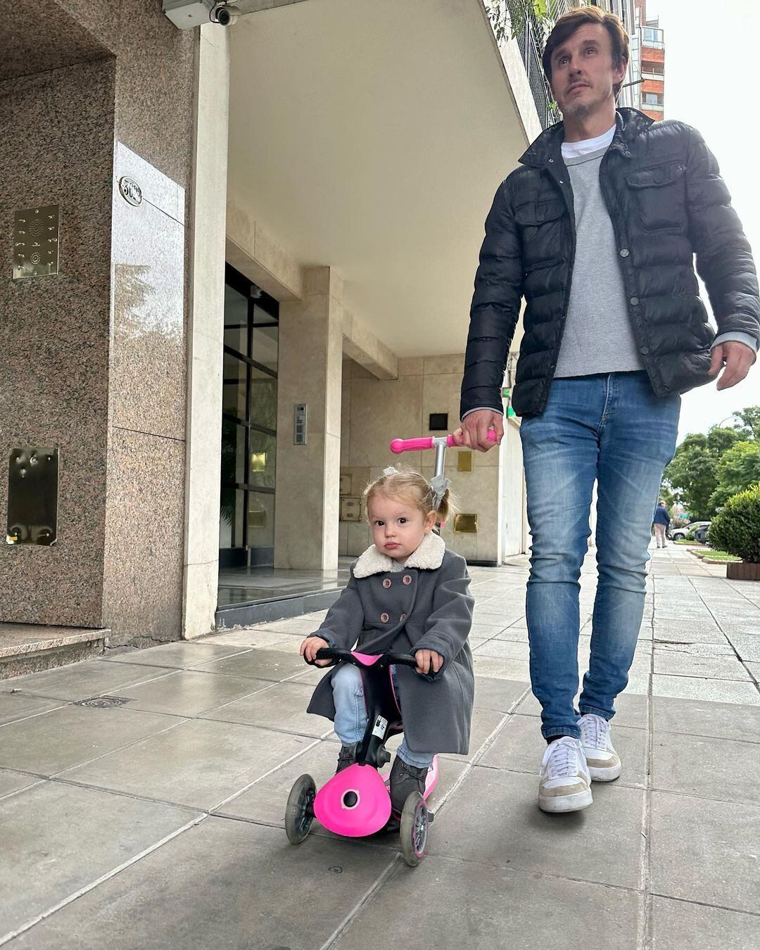 La primogénita del empresario y la modelo dando un paseo junto a su padre por la calle. 