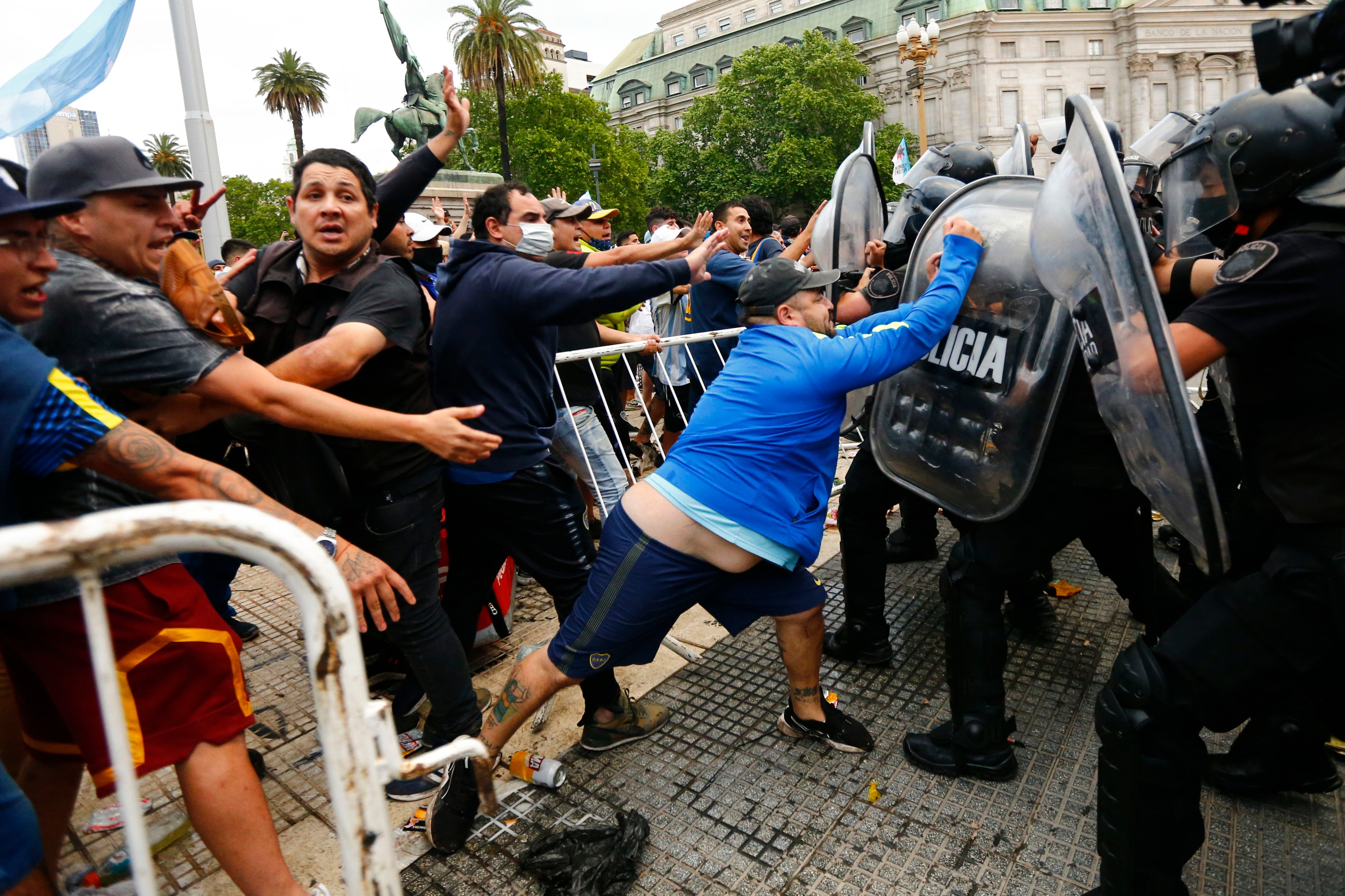 Hinchas de futbol confrontan a la policia a la entrada de la Casa Rosada, sede presidencial, para ver
el feretro que contiene el cuerpo de Diego Maradona, la leyenda del futbol, en Buenos Aires, Argentina, el jueves 26 de noviembre de 2020. Maradona fallecio a los 60 años.