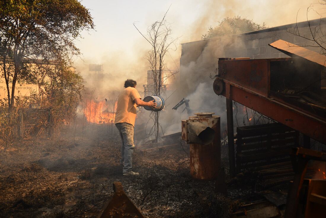 Incendio en una vivienda en Chacras de la Merced. Vecinos combaten las llamas que llegaron a una casa. (José Gabriel Hernández)