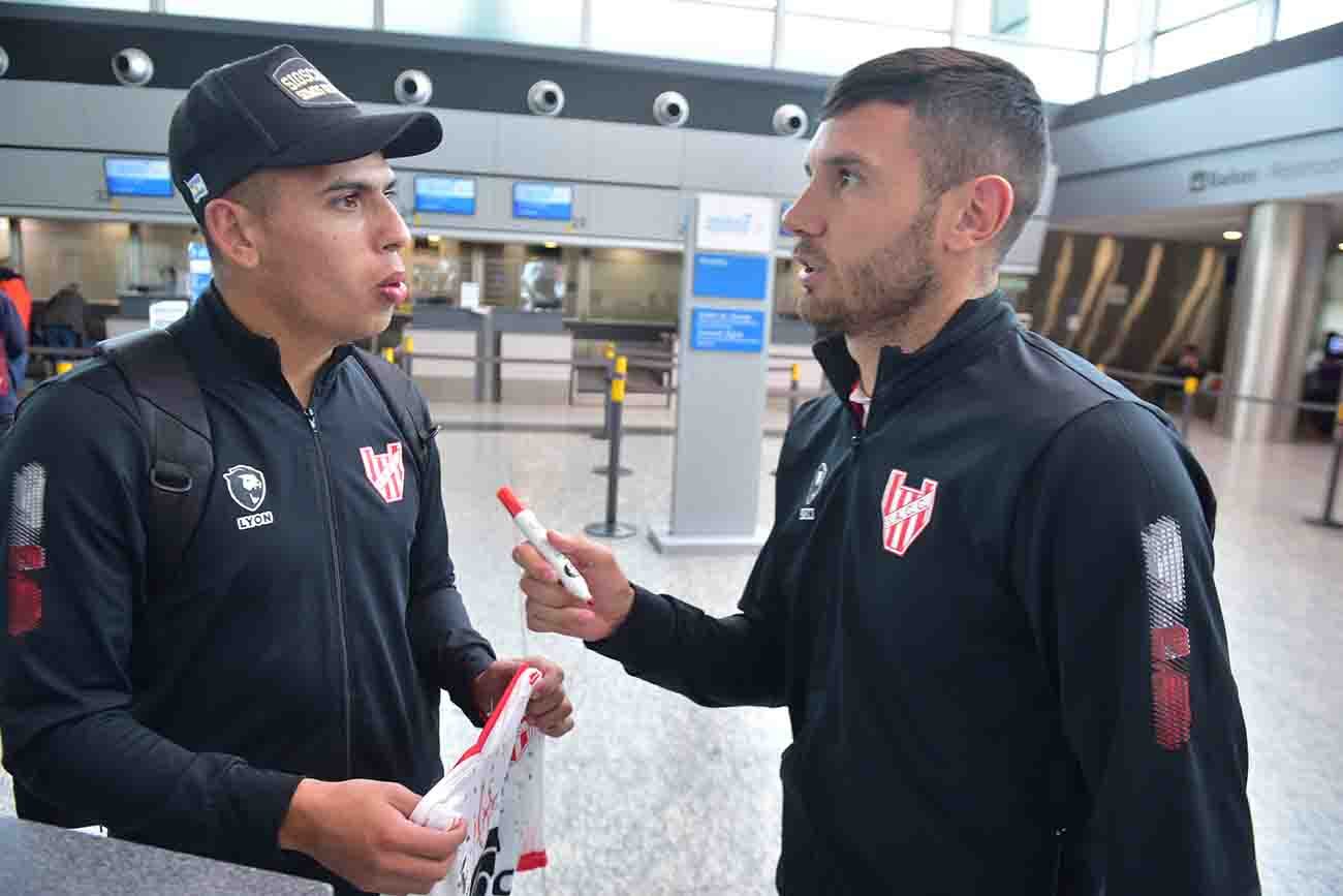 Rodríguez y Martínez firman la camiseta Partida de Instituto desde el  aeropuerto de Córdoba para el partido ante Baraca Central ( Ramiro Pereyra /La Voz)